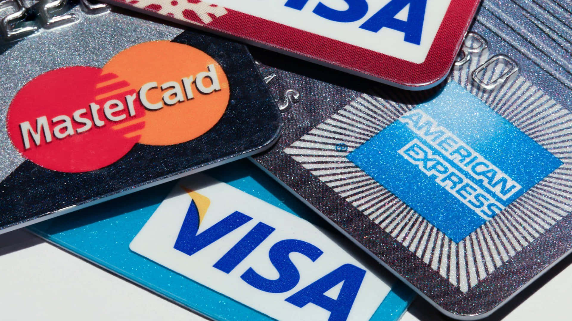一堆帶有 MasterCard、Visa 和 American Express 標誌的信用卡。