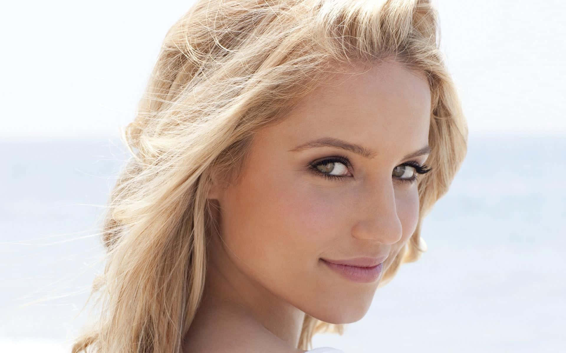 dianna agron 桌布 壁紙 — 金髮女子嘅特寫肖像，帶住溫柔嘅微笑，背景係明亮模糊嘅海洋。