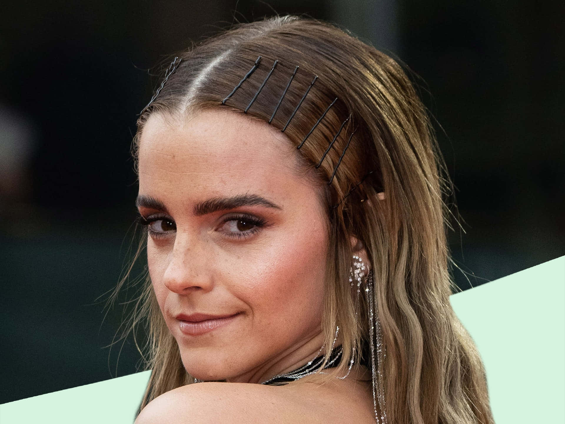 Emma Watson 桌布 壁紙 — 金髮女子特寫肖像，頭髮以黑色 Bobby 夾造型，佩戴垂墜耳環。