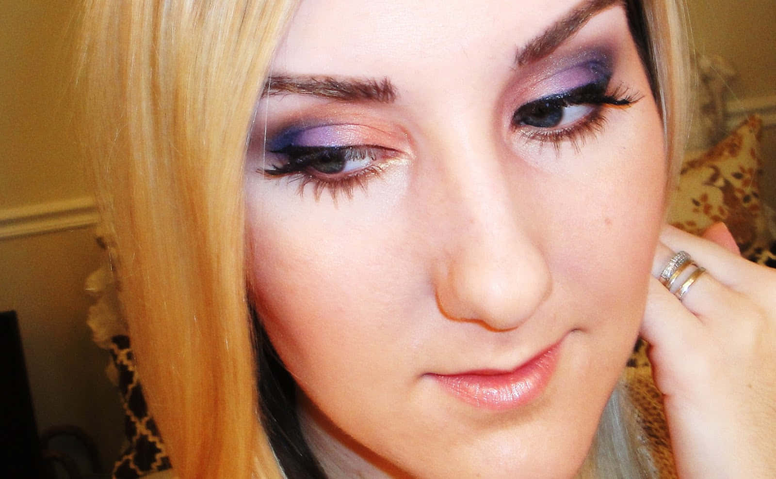 Spring Makeup 桌布 壁紙 — 金髮女子近距離特寫，帶有鮮豔紫色眼影，輕柔凝視並觸碰臉頰。