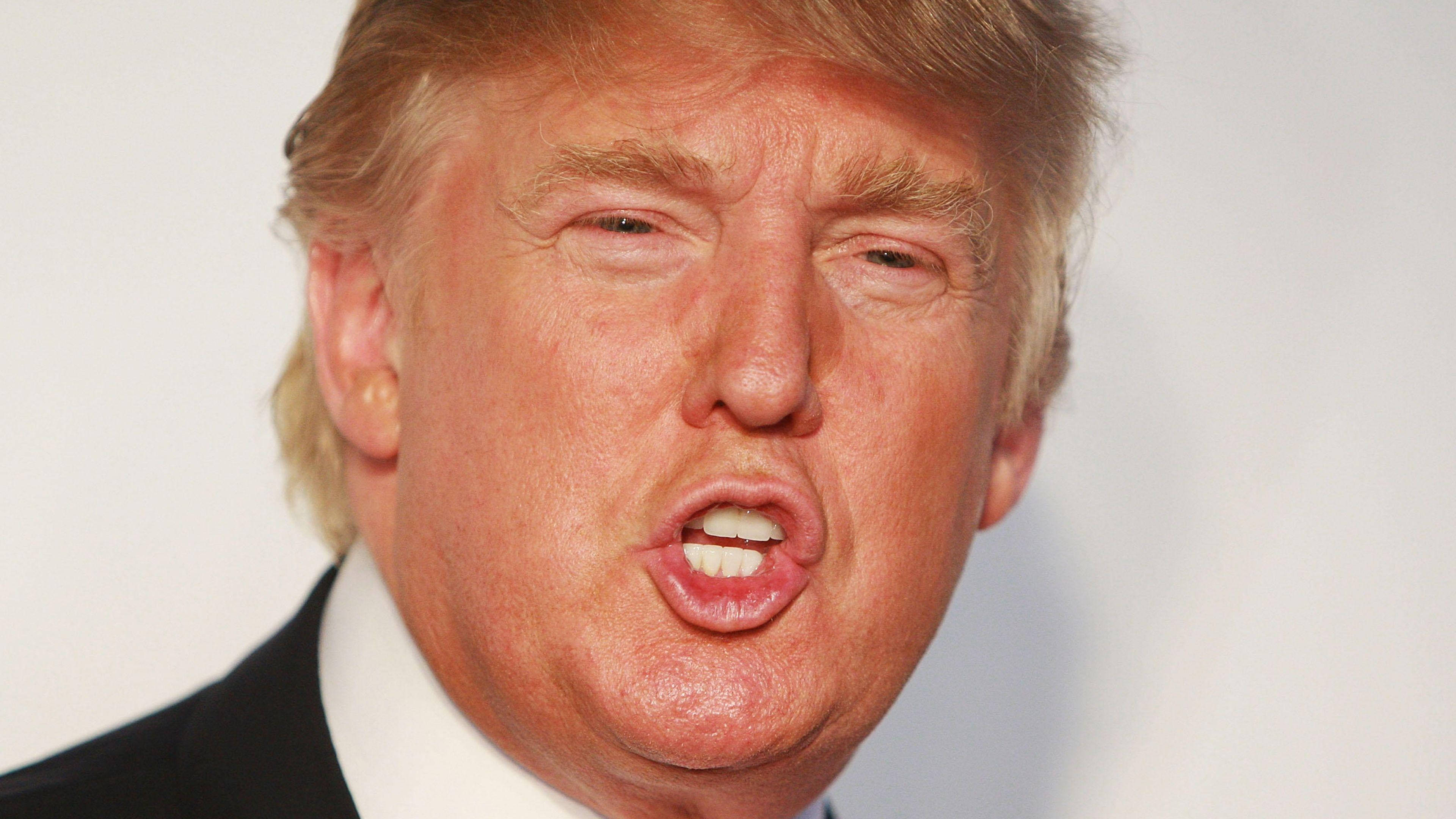 donald trump 桌布 壁紙 — 金髮男子身穿西裝，在純白色背景前做出表情豐富的臉部特寫。