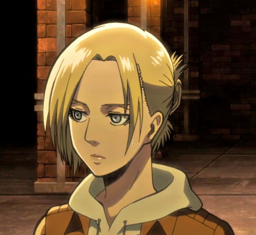 Annie Leonhart 桌布 壁紙 — 金髮藍眼動漫角色的特寫，流著眼淚，站在昏暗的磚牆房間裡。