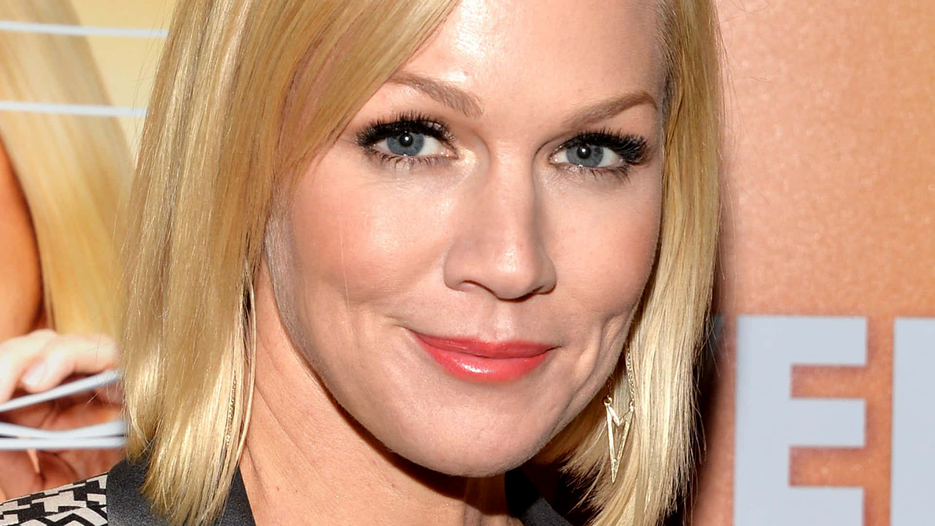 Jennie Garth 桌布 壁紙 — 金髮藍眼紅唇女子對著鏡頭微笑的特寫肖像。