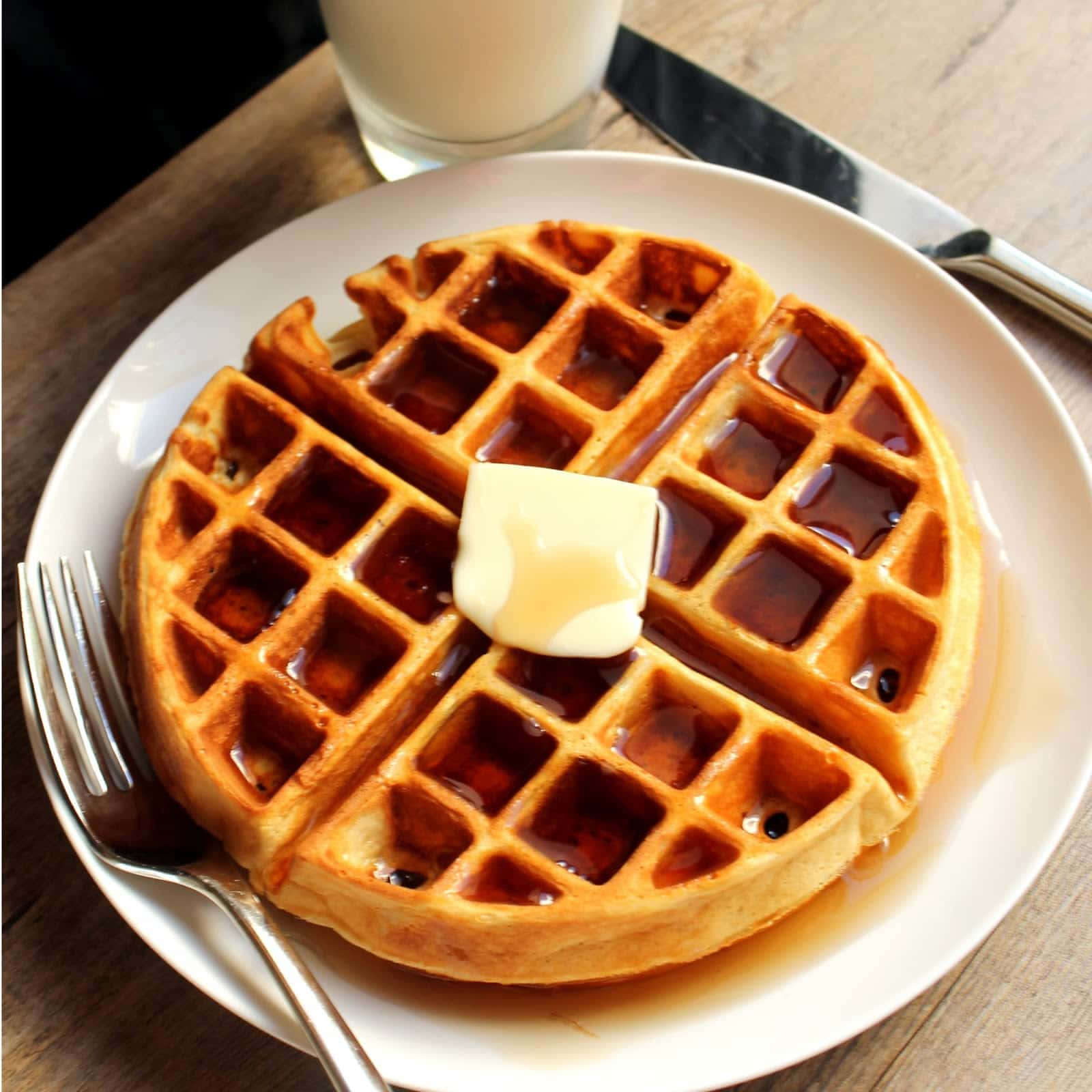 Waffle 桌布 壁紙 — 金黃色窩夫淋上糖漿，配上融化牛油，放在白色碟上，旁邊有一杯牛奶。