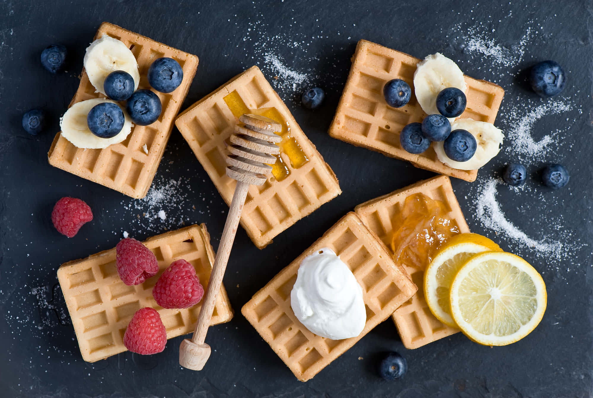 Waffle 桌布 壁紙 — 金黃色窩夫配上莓果、蜂蜜和忌廉，擺放在深色石板表面上。