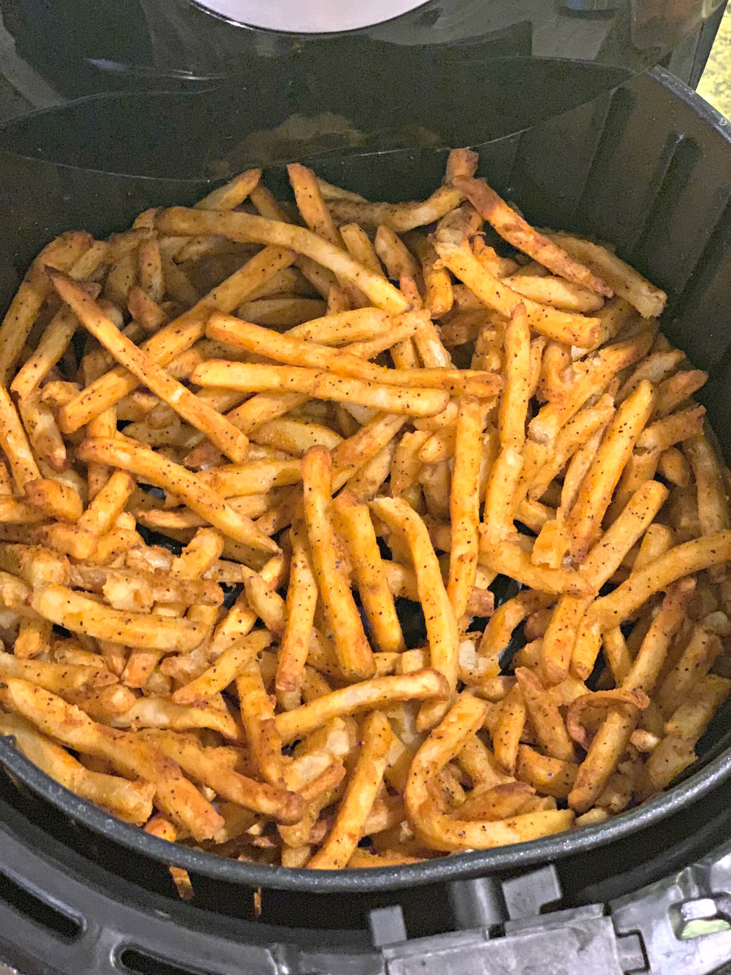 薯條 桌布 壁紙 — 金黃酥脆的炸薯條，以黑胡椒調味，裝滿黑色氣炸鍋籃。