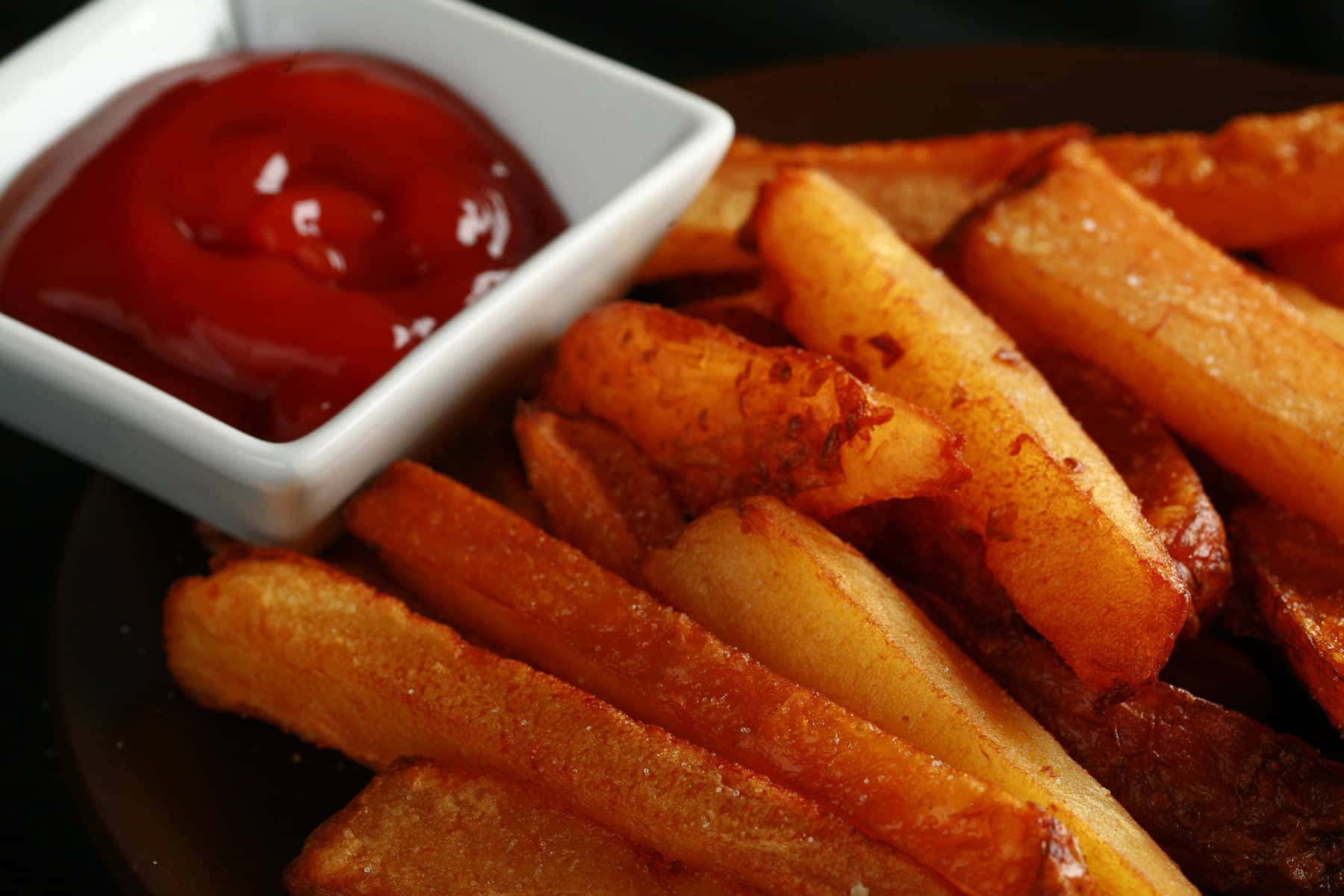 French Fries 桌布 壁紙 — 金黃酥脆的薯條高高堆起，旁邊放著一碟閃亮的紅色茄汁。