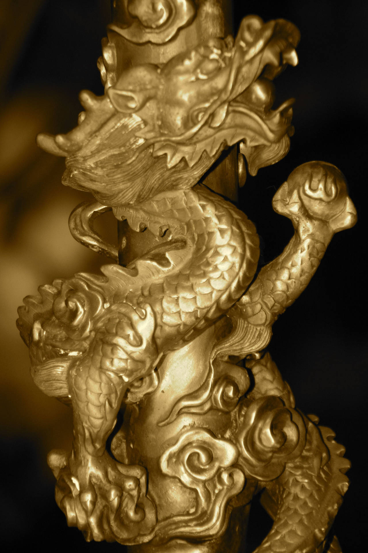 金色龍雕塑纏繞在柱子上，帶有精細的鱗片和飄逸的鬃毛。