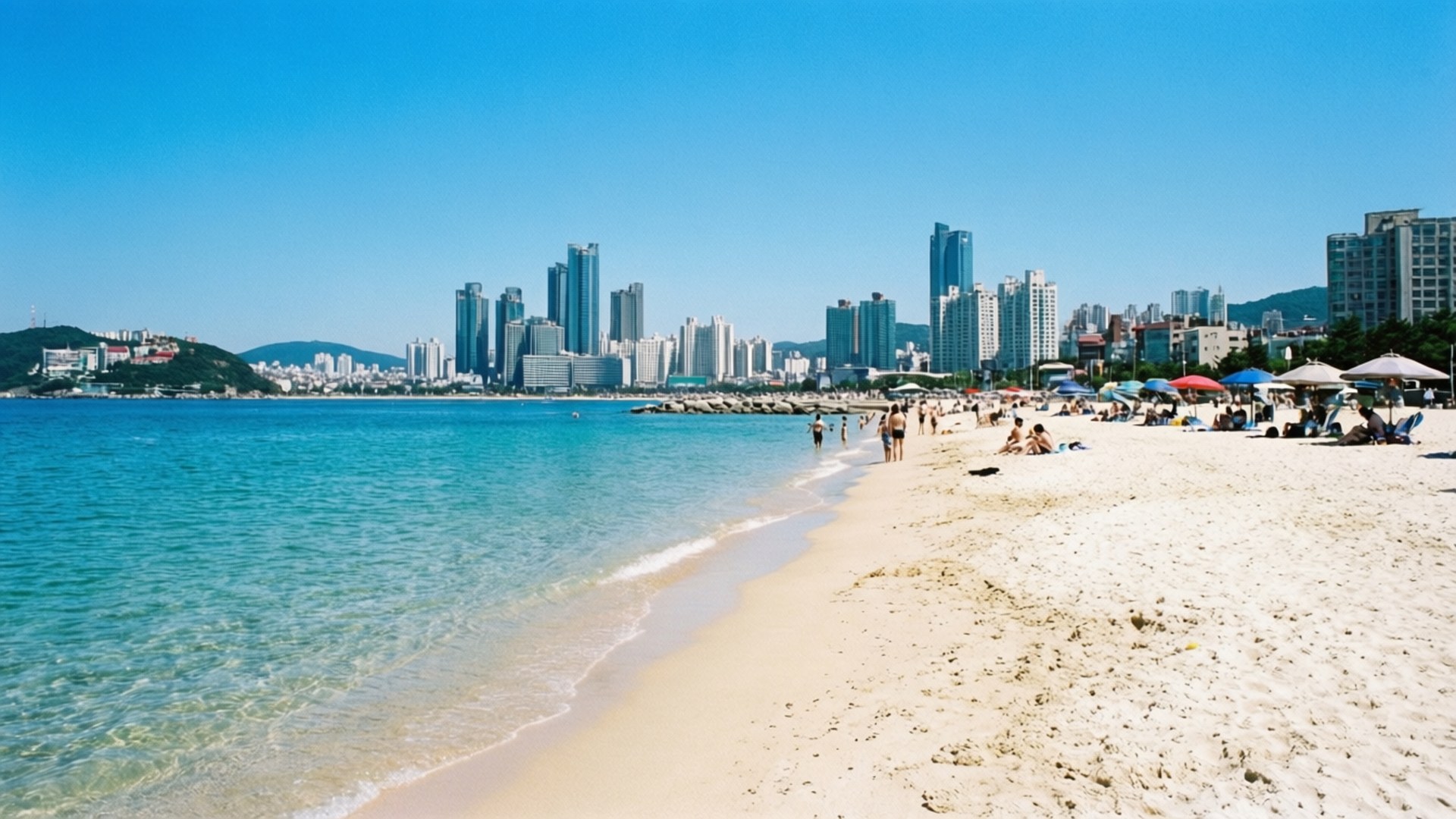 清澈藍色海水和背景城市天際線的海灘