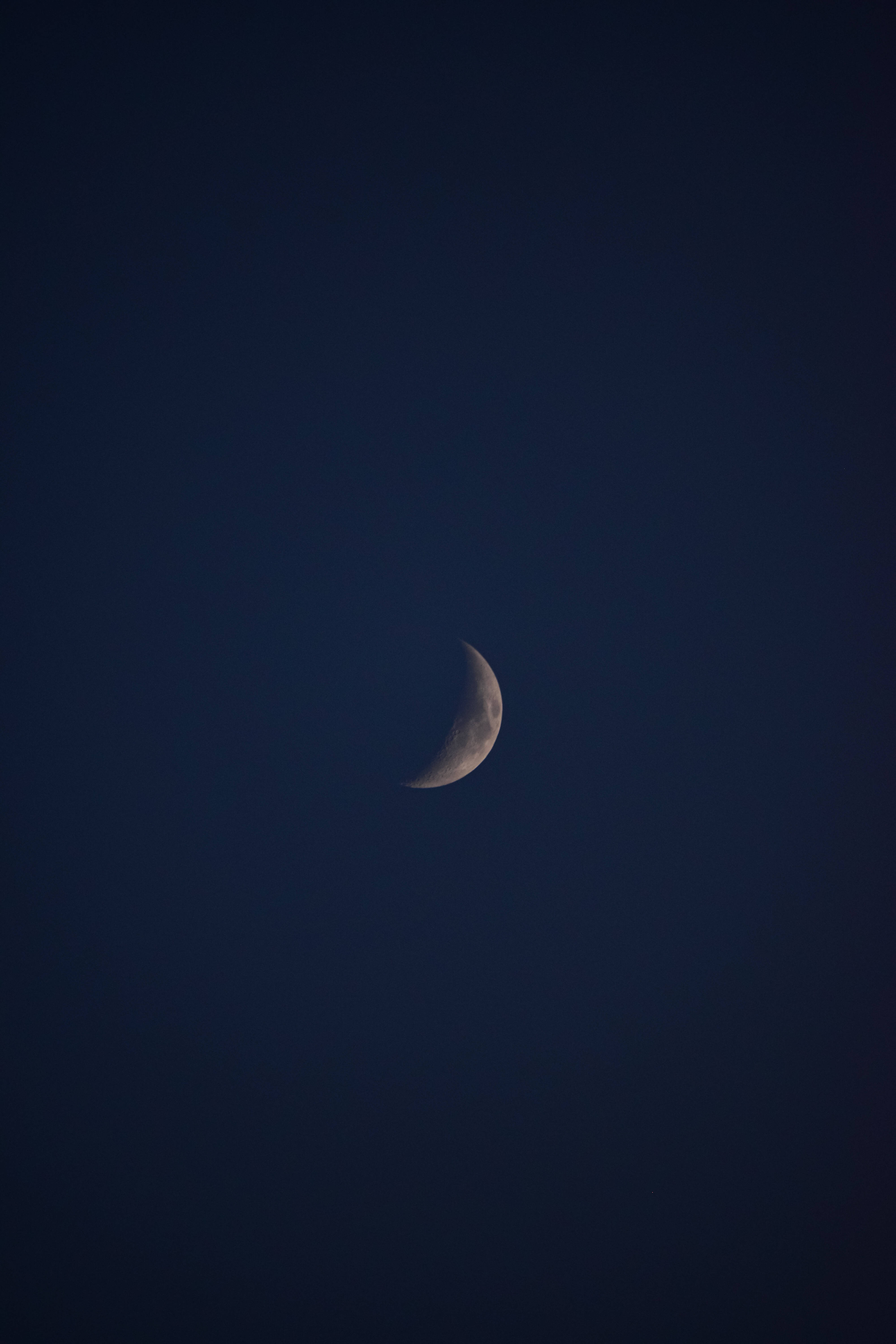 銀河中的娥眉月 壁紙 — 一彎纖細的月牙在深靛藍色的夜空中柔和地發光。