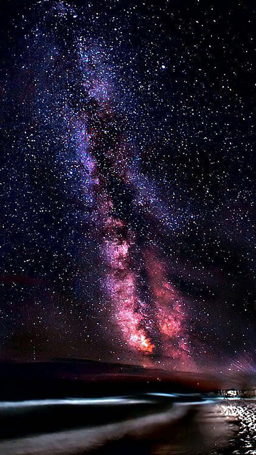 銀河系在夜晚的黑暗沙灘上閃耀