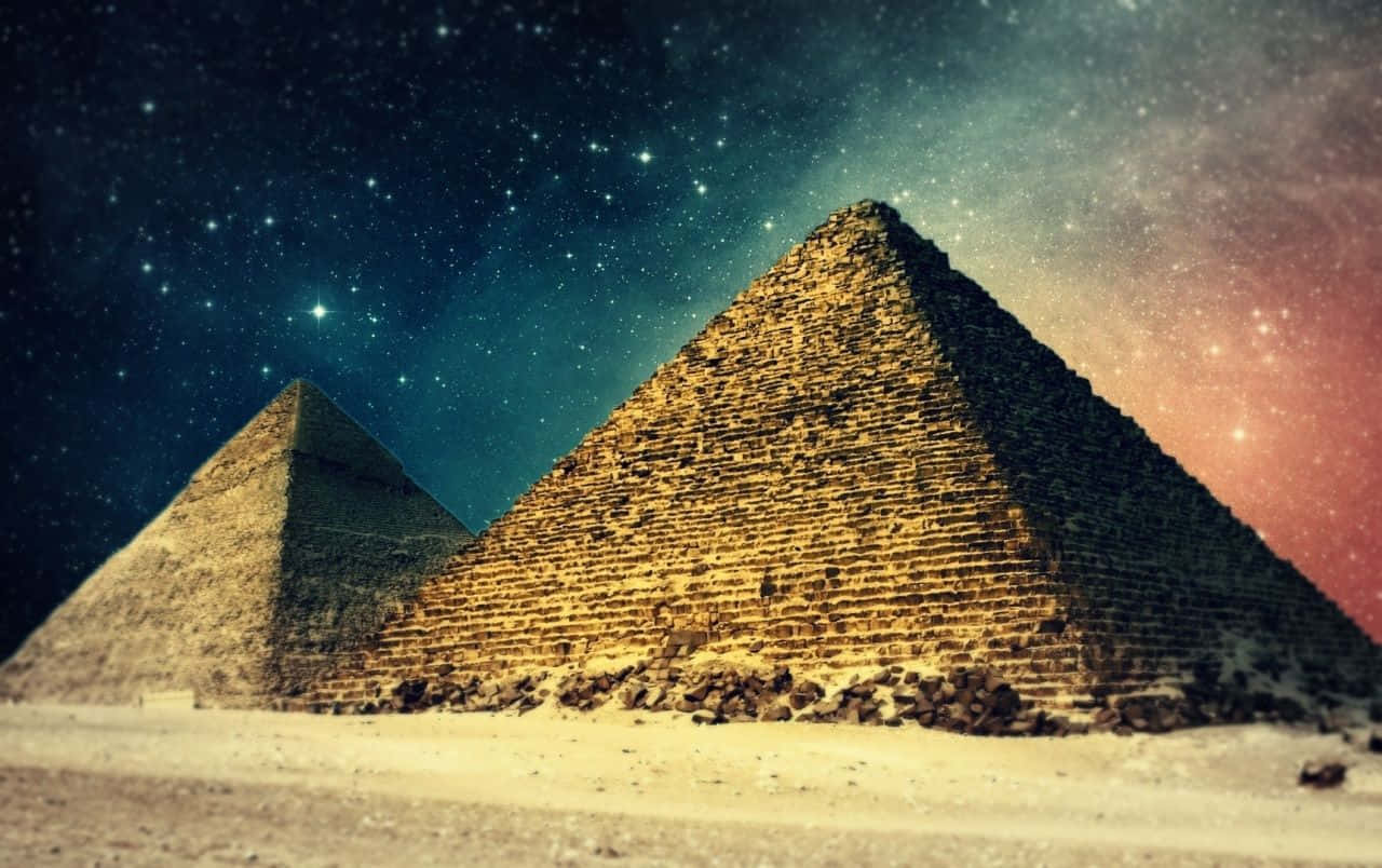 銀河天空覆蓋吉薩金字塔 壁紙 — 兩座古老金字塔在繁星點點的夜空下巍然聳立，宇宙色調在天空中交織融合。