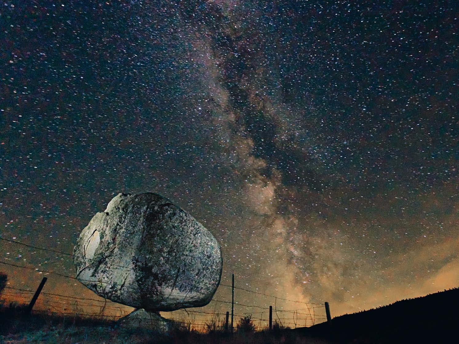 星空夜空下的一塊大岩石，銀河可見。