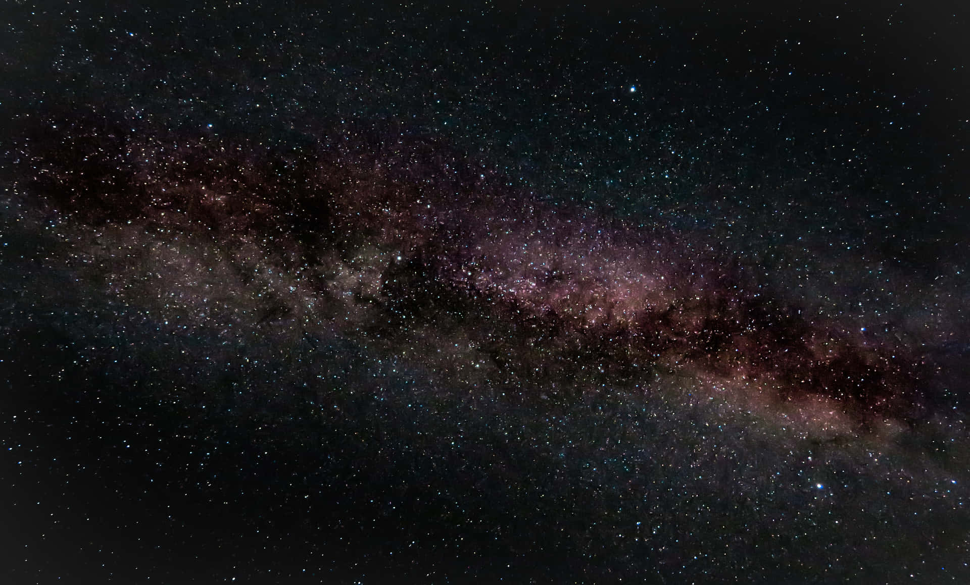 銀河系帶有紫色和粉紅色星雲，背景是佈滿星星的夜空。