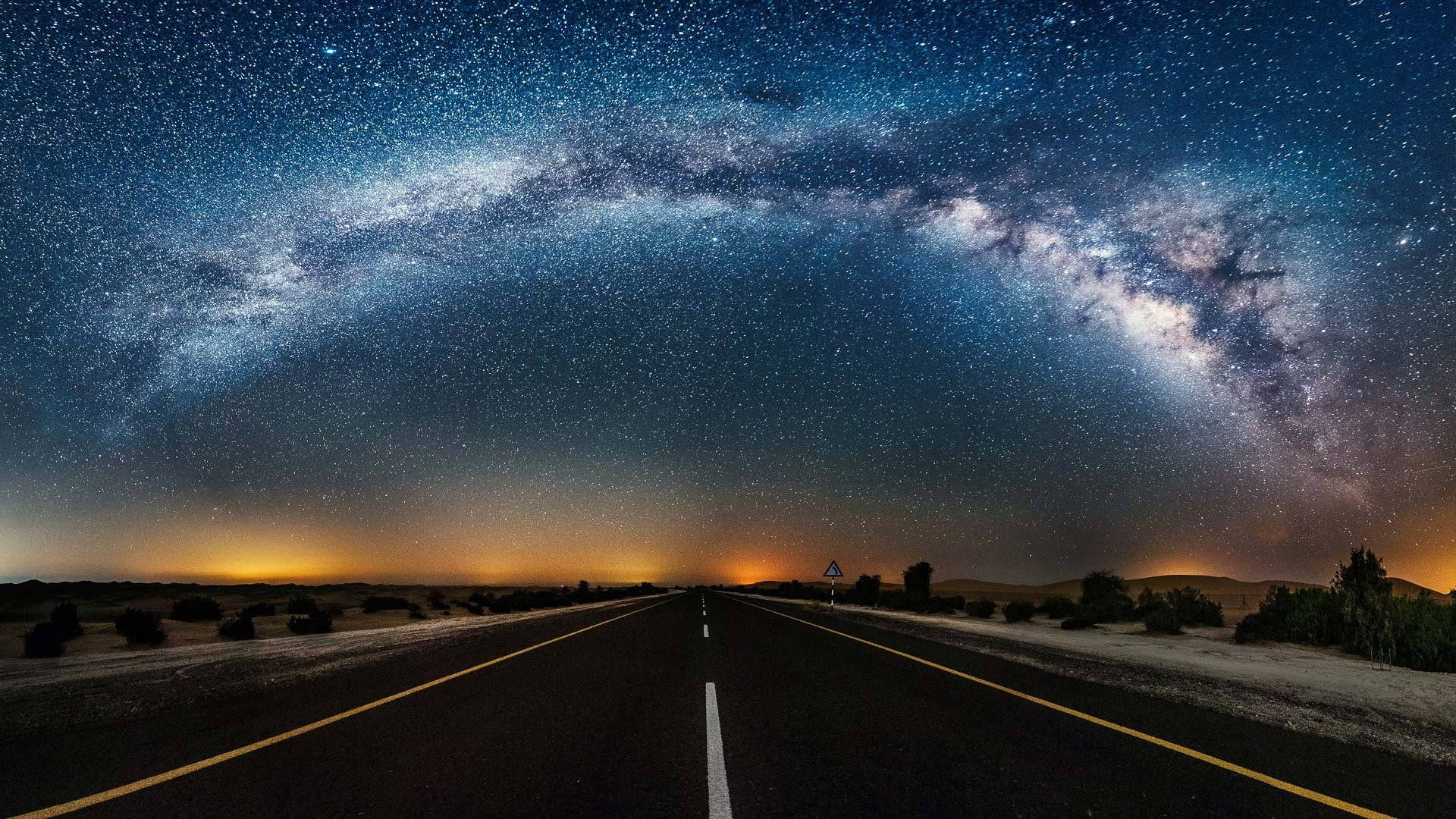 一條黑暗的道路在星空下延伸，上方可見銀河。