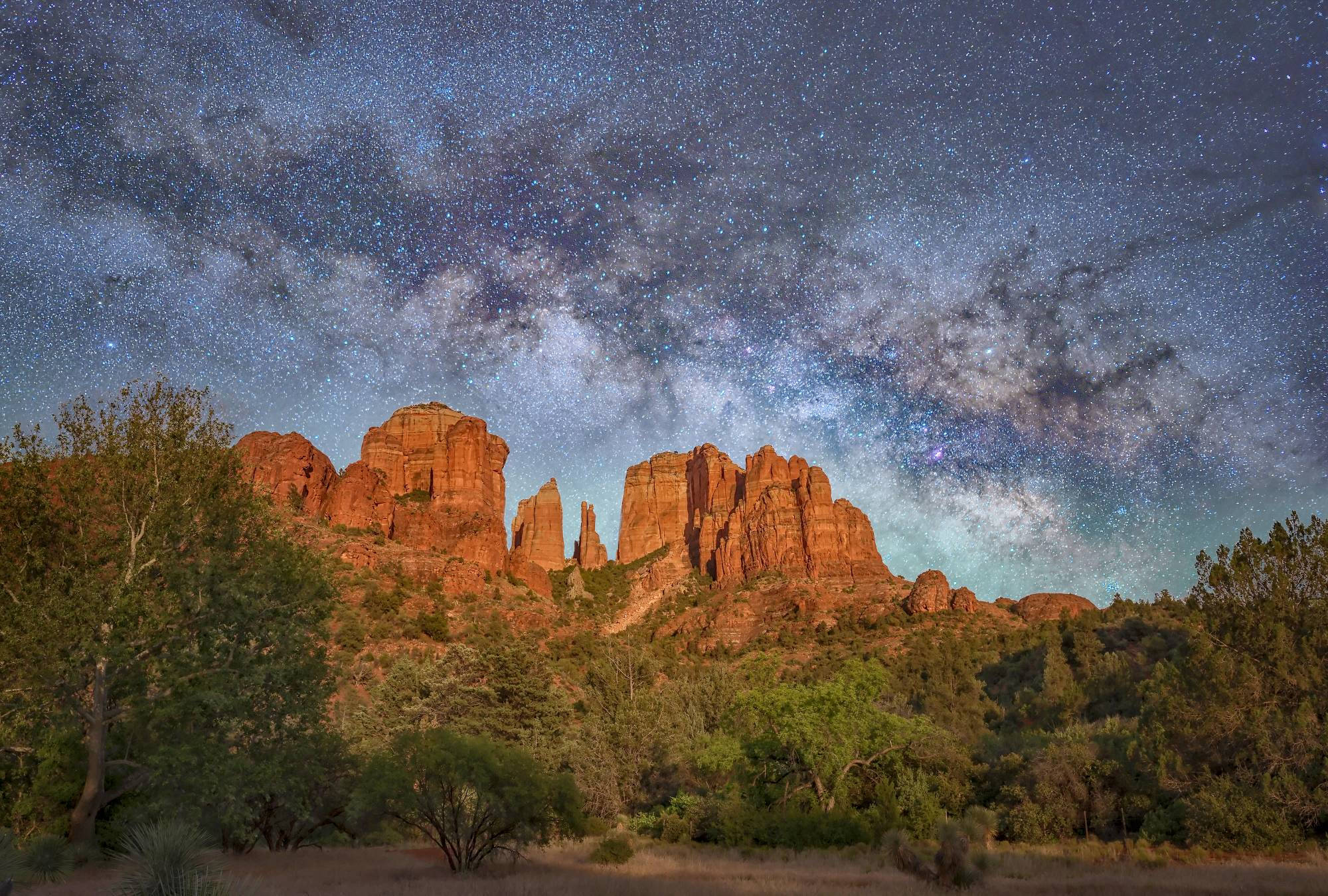 Arizona 桌布 壁紙 — 銀河系在繁星點點的沙漠夜空下，拱形跨越雄偉的紅色岩層。