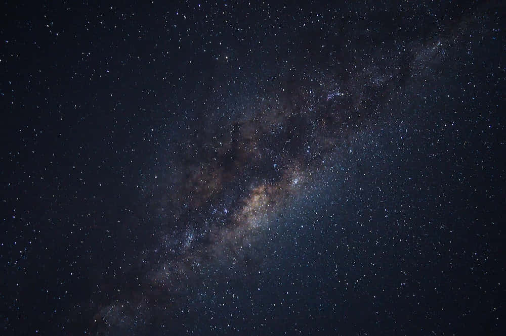 銀河系塵埃雲星海圖 壁紙 — 令人驚嘆的銀河系景觀，在深靛藍色的夜空中閃爍著無數恆星和宇宙塵埃。