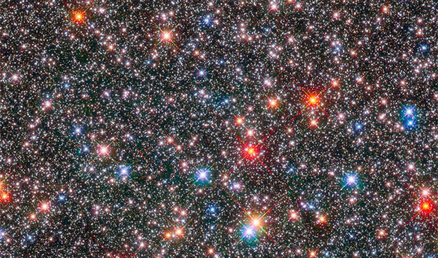 銀河系核心星海 壁紙 — 密集嘅彩色星星喺深邃黑色宇宙背景下閃爍，帶有鮮豔嘅紅色、藍色同白色恆星耀斑。
