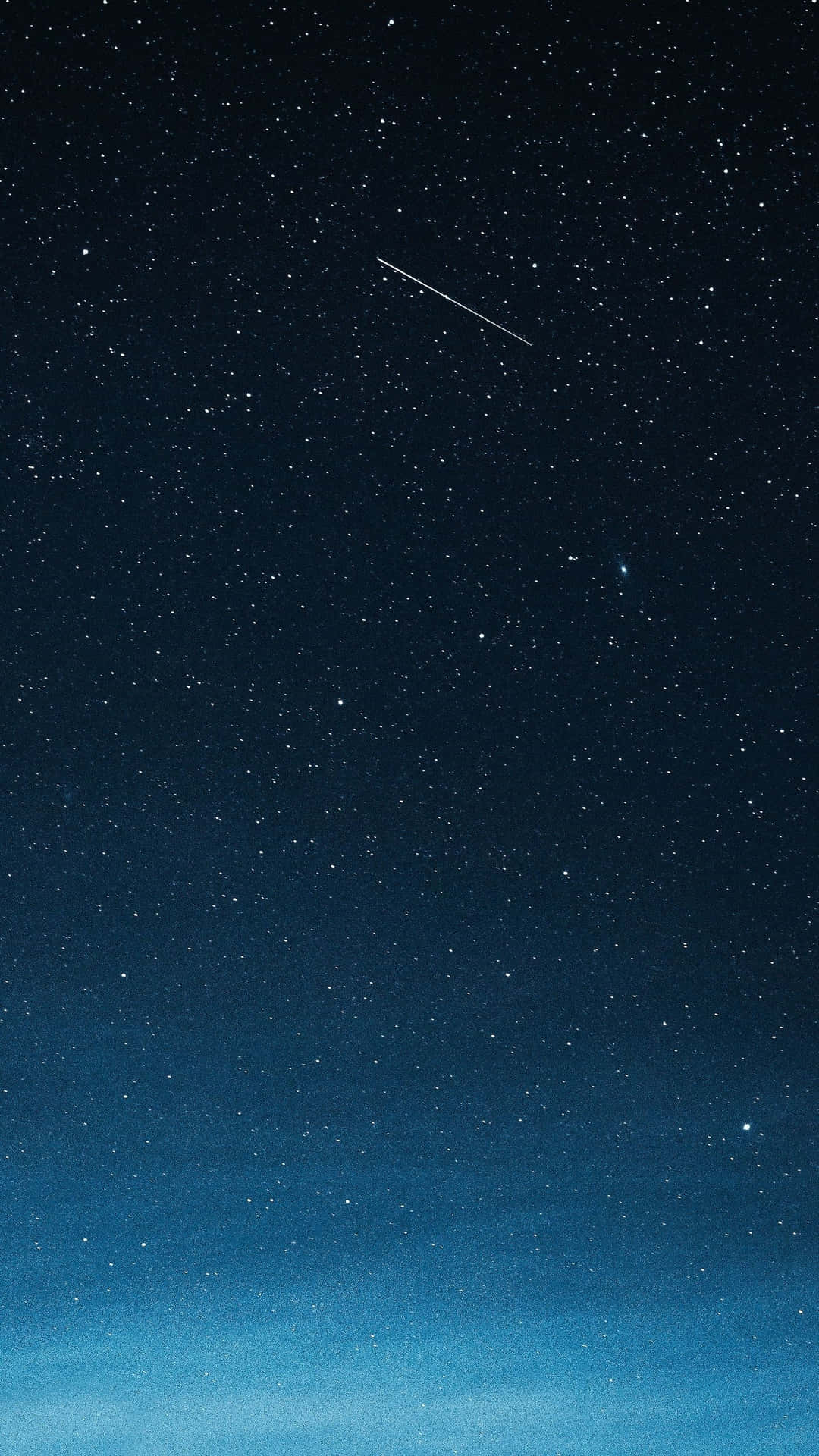 一顆流星劃過深藍色色調的星空夜空。