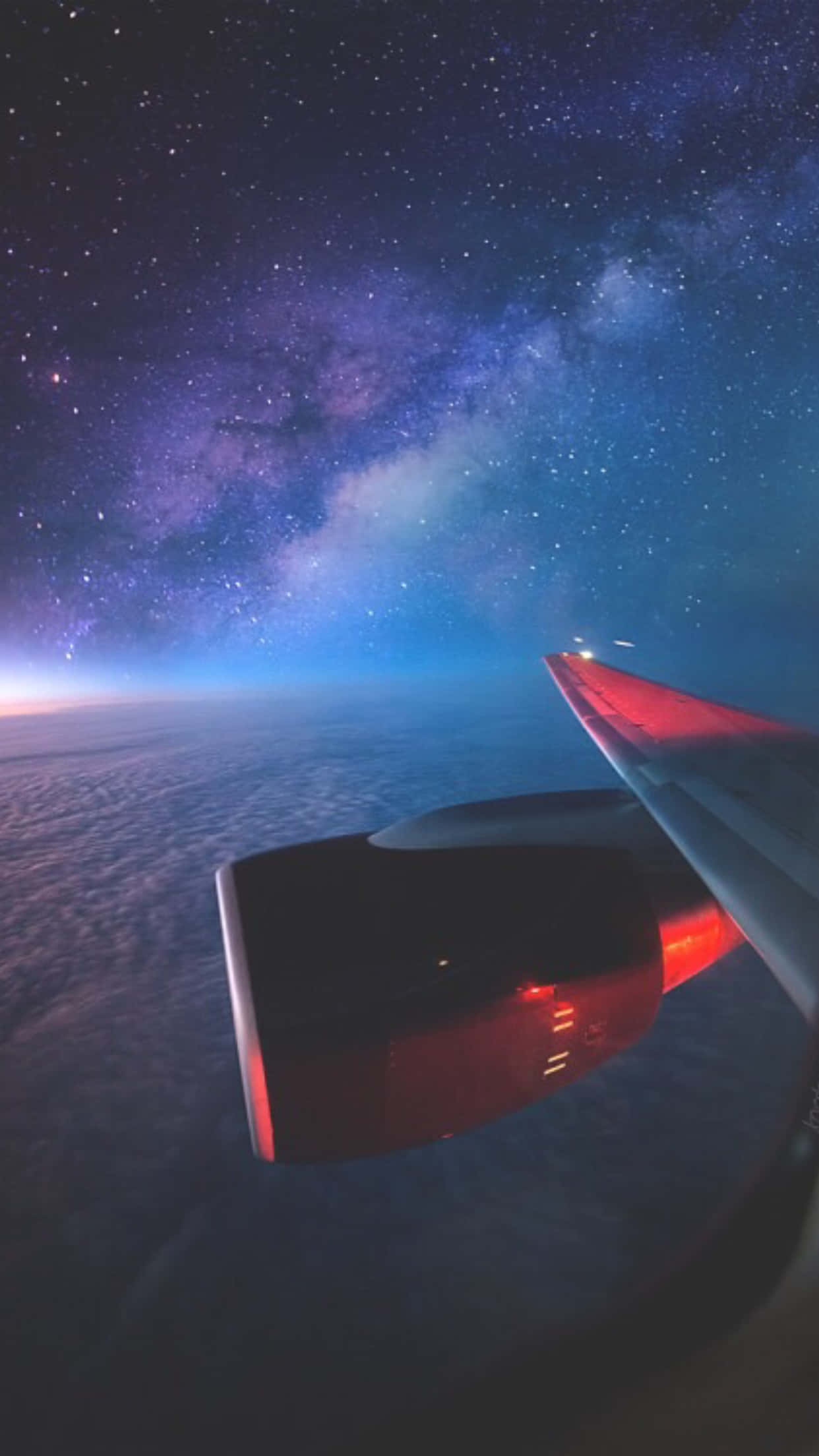 銀河視野 Android 飛機背景 壁紙 — 飛機機翼在繁星點點的夜空下發出紅光，上方有銀河，下方有雲層。