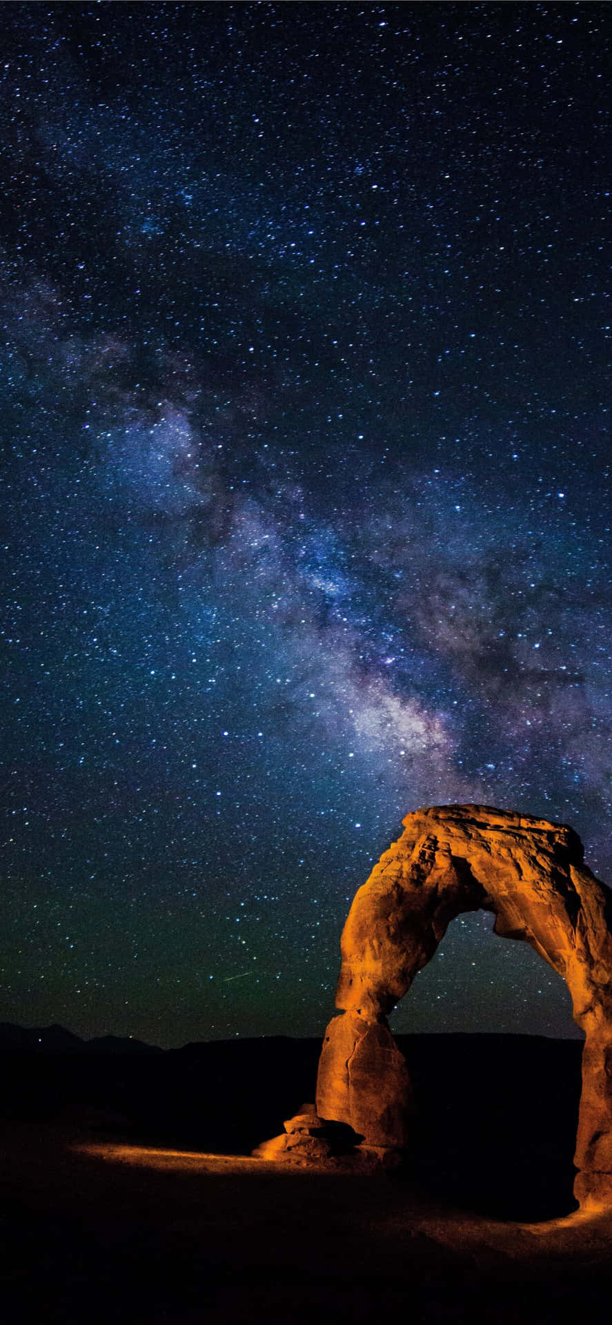 在可見銀河系的星空夜空下，一座發光的石拱門。