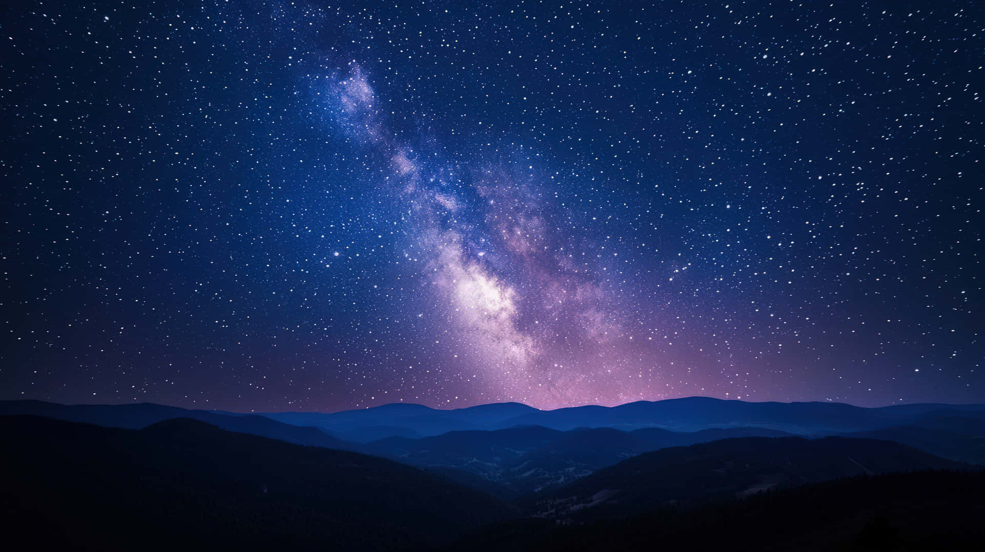 銀河系在星夜下於黑暗山脈剪影上方發光