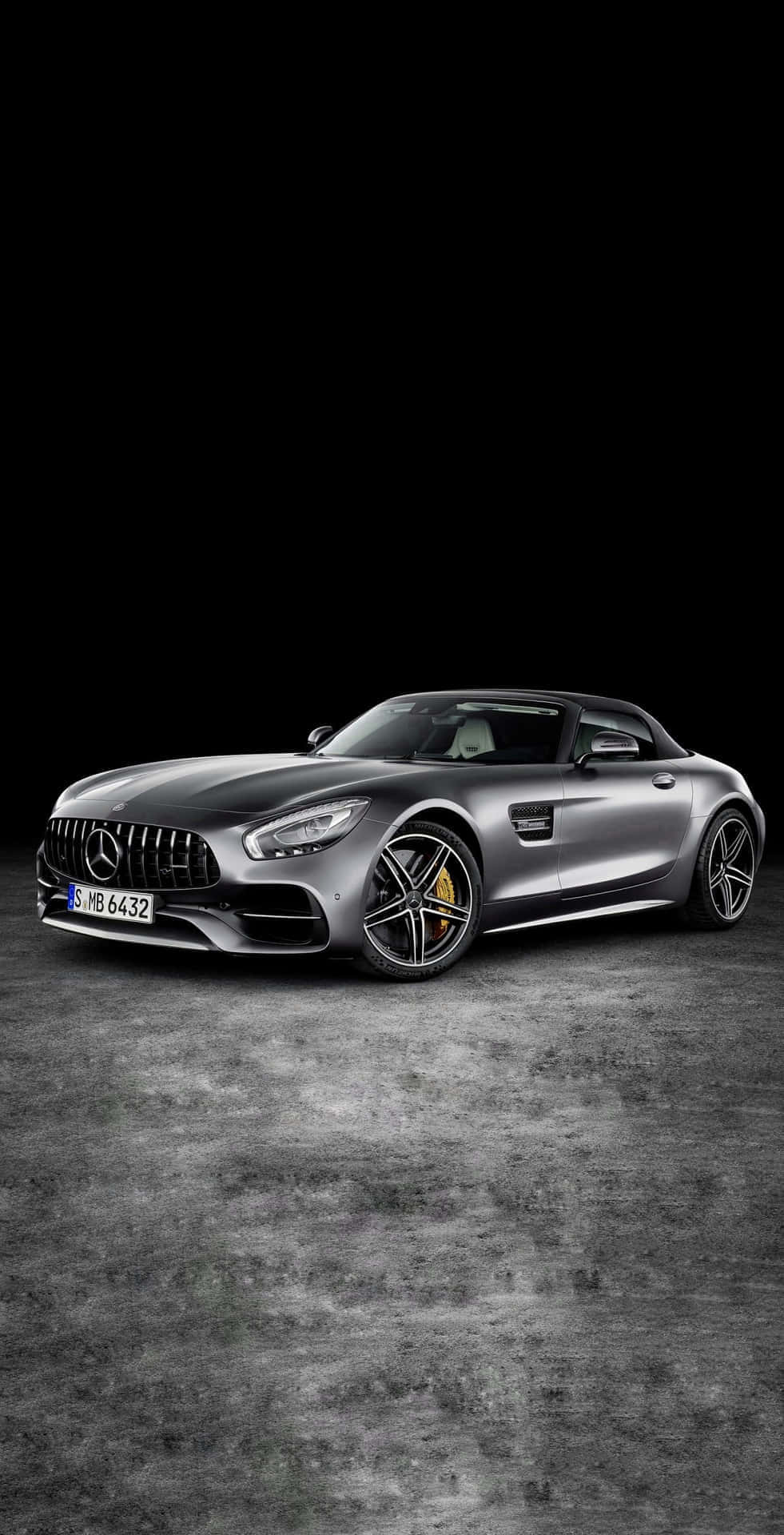 銀灰AMG GT-R黑調安卓背景 壁紙 — 一輛時尚的銀色 Mercedes-AMG GT Roadster 停放在紋理混凝土地板上，背景為純黑色。