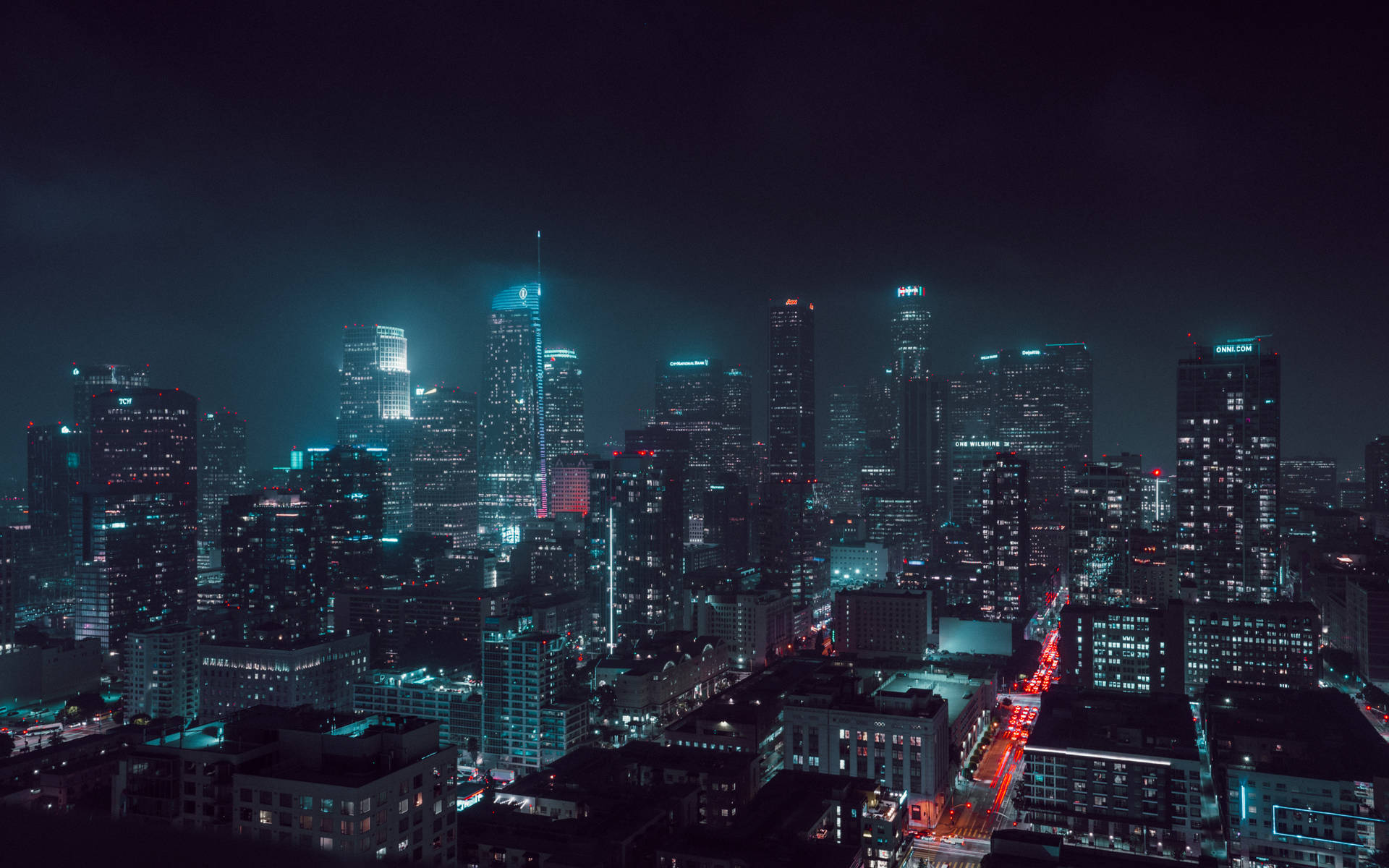 夜晚的城市景觀，摩天大樓燈火通明，街道繁忙。