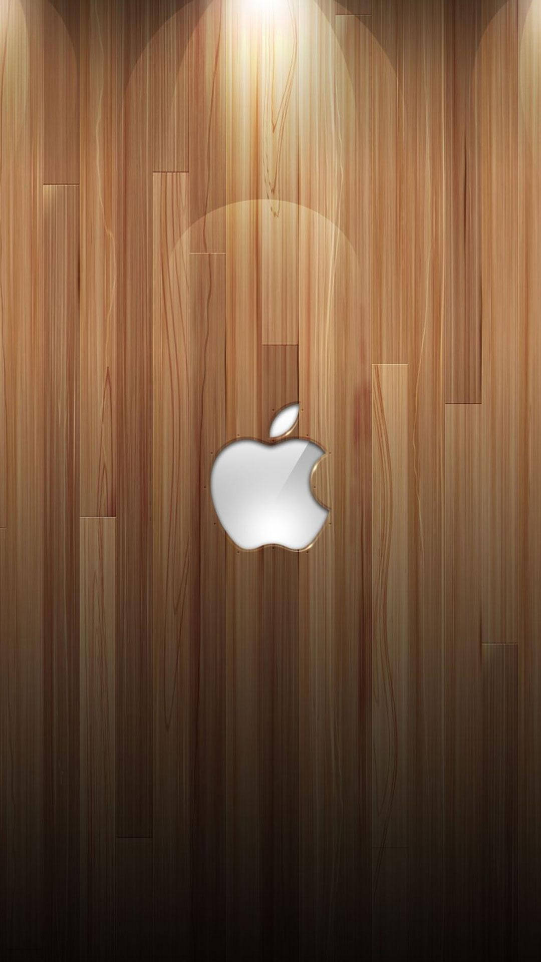 銀色 Apple 標誌 iPhone 6s Plus 壁紙 — 一個時尚的銀色Apple標誌，置於溫暖木紋面板背景中央，配以柔和燈光。