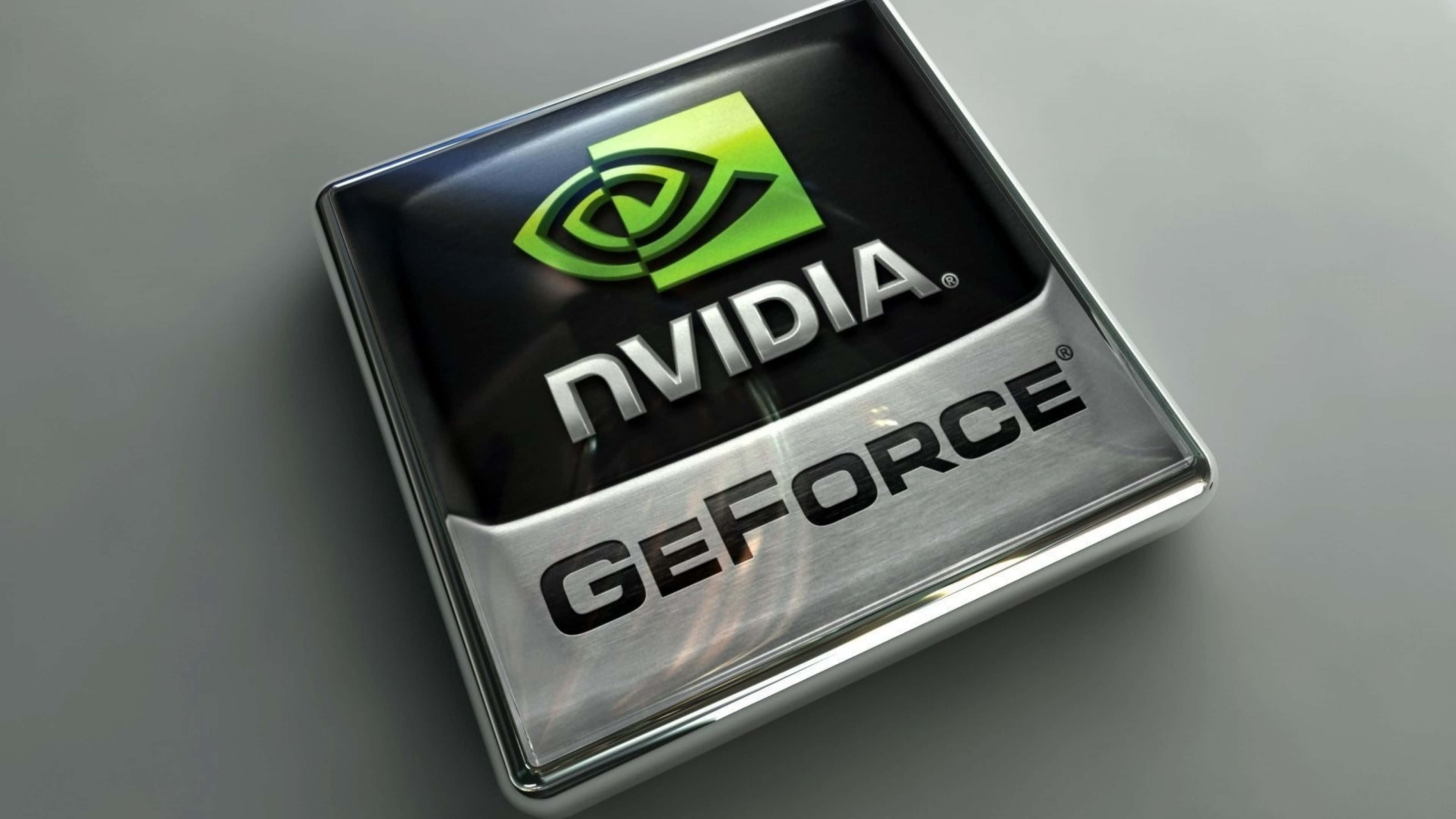 銀色 NVIDIA 4K UHD 壁紙 — 近距離拍攝一個光滑的NVIDIA GeForce標誌，位於金屬方形徽章上，帶有綠色眼睛標誌和銀色文字。