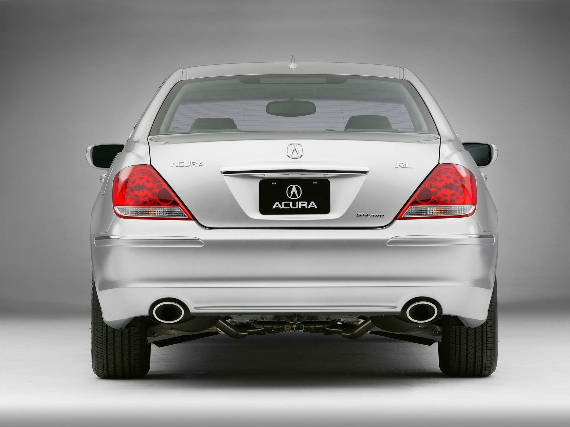 銀色Acura RL轎車後視圖，帶有紅色尾燈和雙排氣管。