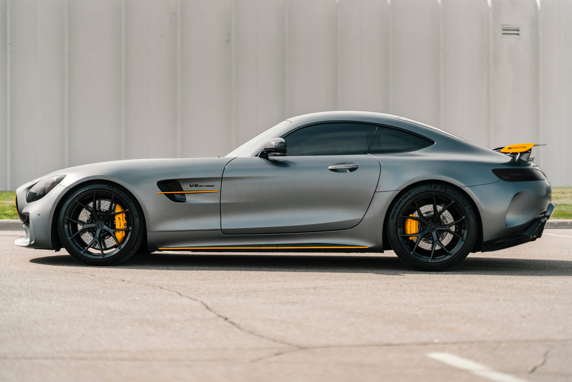 啞光灰色AMG GT S跑車，帶有黃色制動卡鉗，停在路面上。
