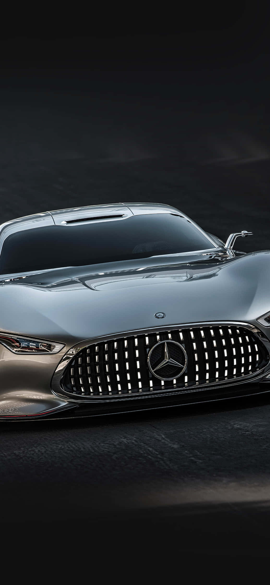 銀色iPhone XS與梅賽德斯-AMG背景，車身反光 壁紙 — 一架時尚的銀色 Mercedes 跑車，帶有發光格柵和鋒利頭燈，主導著黑暗的攝影棚環境。