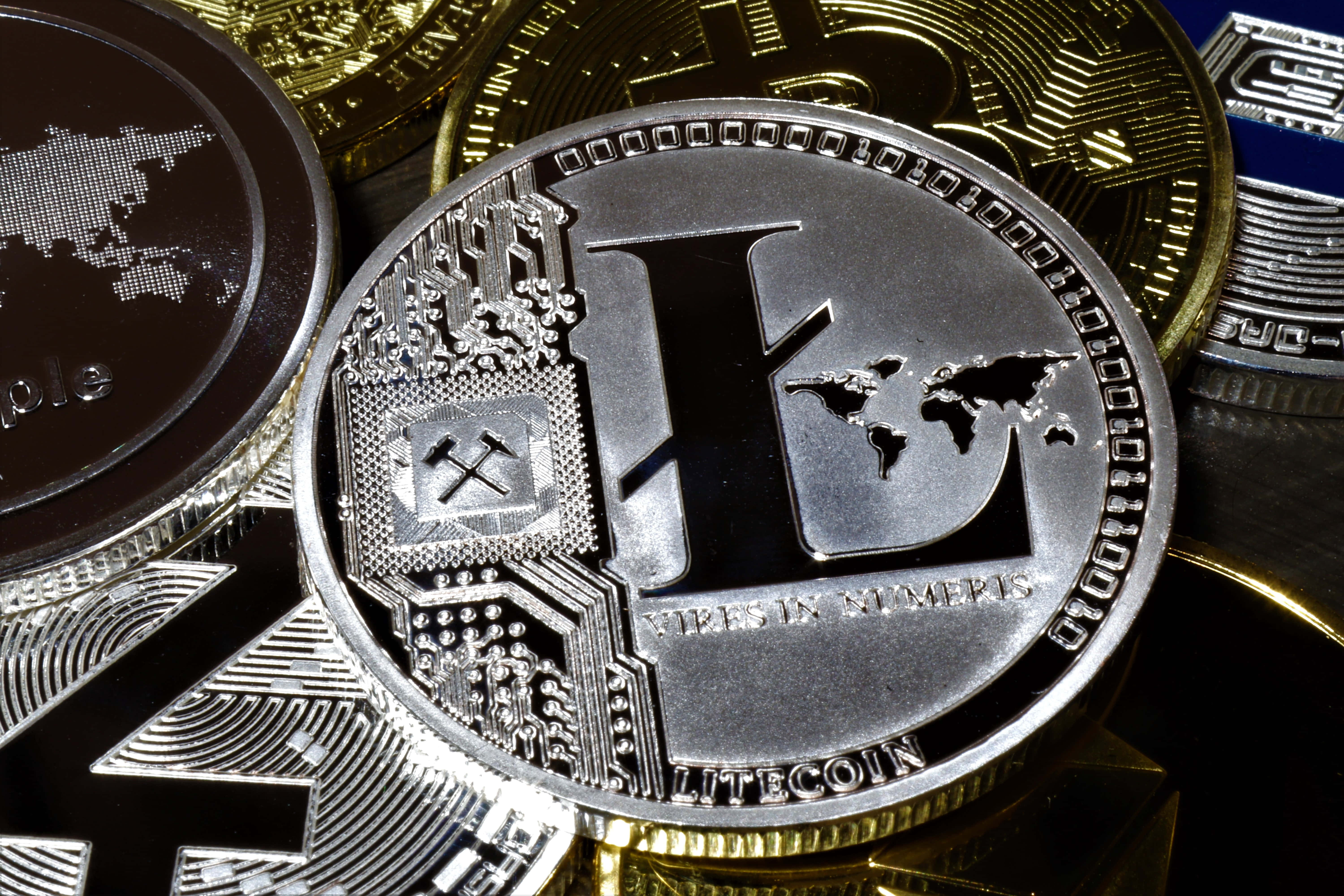Mining 桌布 壁紙 — 銀色Litecoin硬幣特寫，帶有電路和世界地圖細節，被金幣包圍。