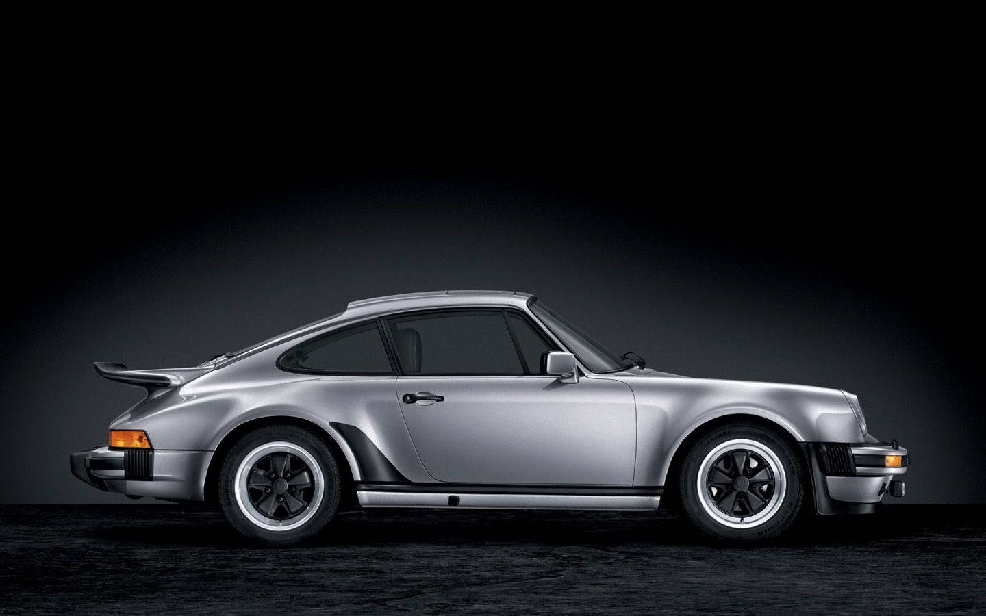 銀色保時捷911 Turbo跑車在攝影棚中配以戲劇性燈光。