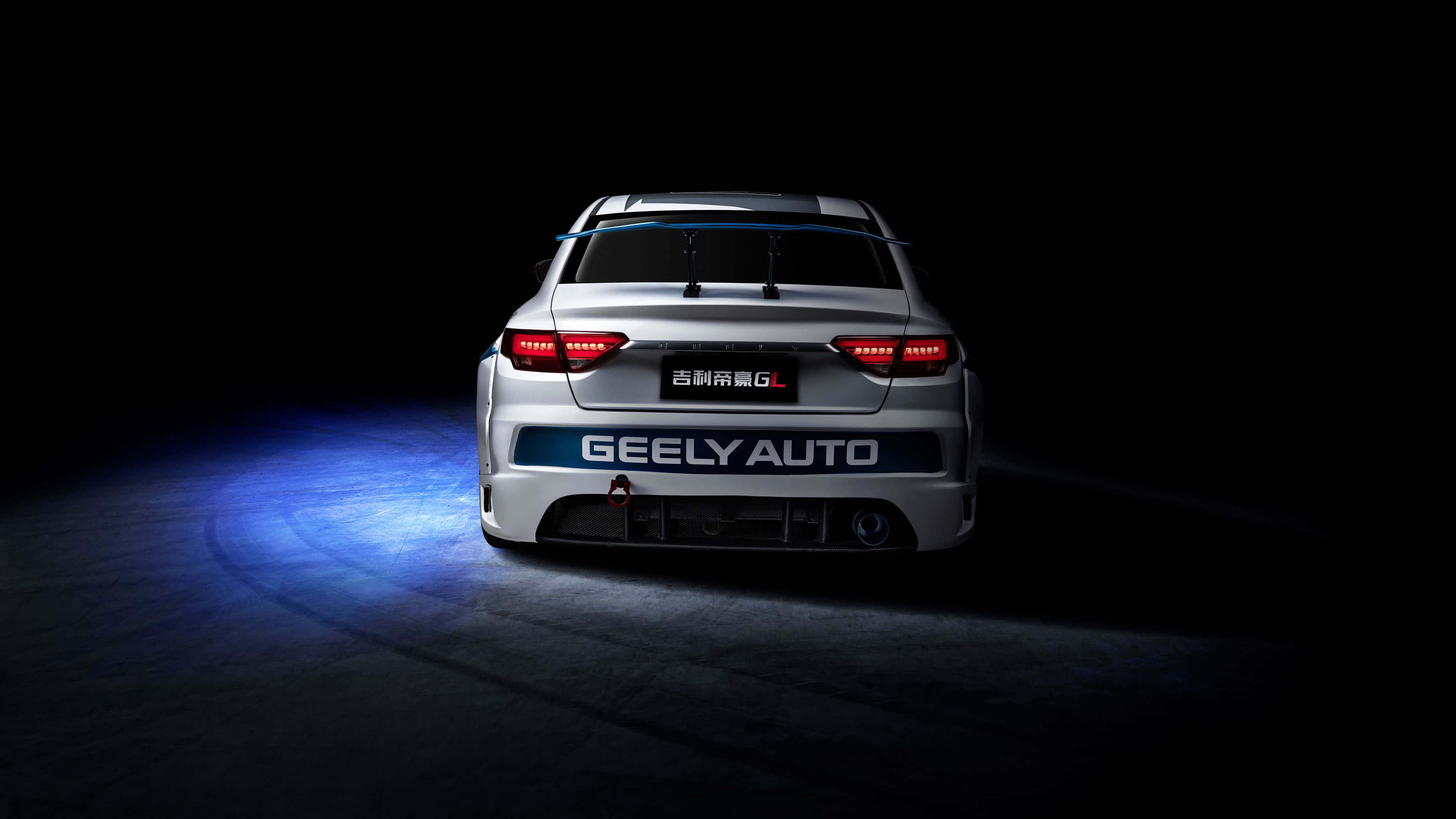 Geely 桌布 壁紙 — 銀色吉利汽車的車尾在戲劇性的藍色和紅色燈光下，在漆黑的攝影棚背景中閃耀。