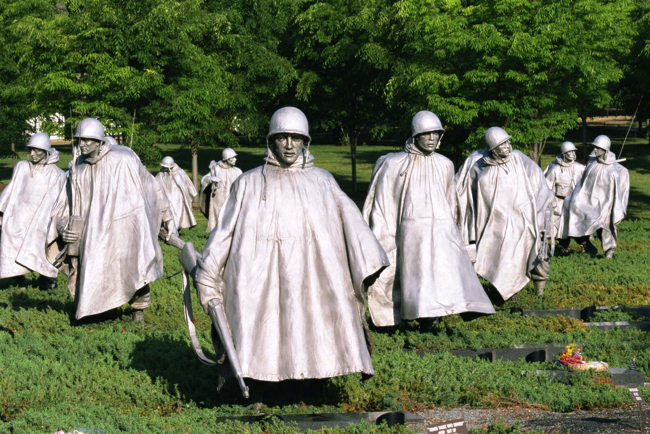 Memorial 桌布 壁紙 — 銀色嘅士兵雕像穿著斗篷同頭盔，喺明亮嘅綠樹下嘅草地上行進。