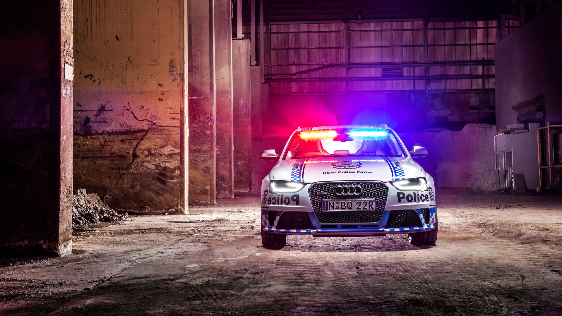 一輛警車在黑暗的廢棄倉庫內閃爍著燈光。