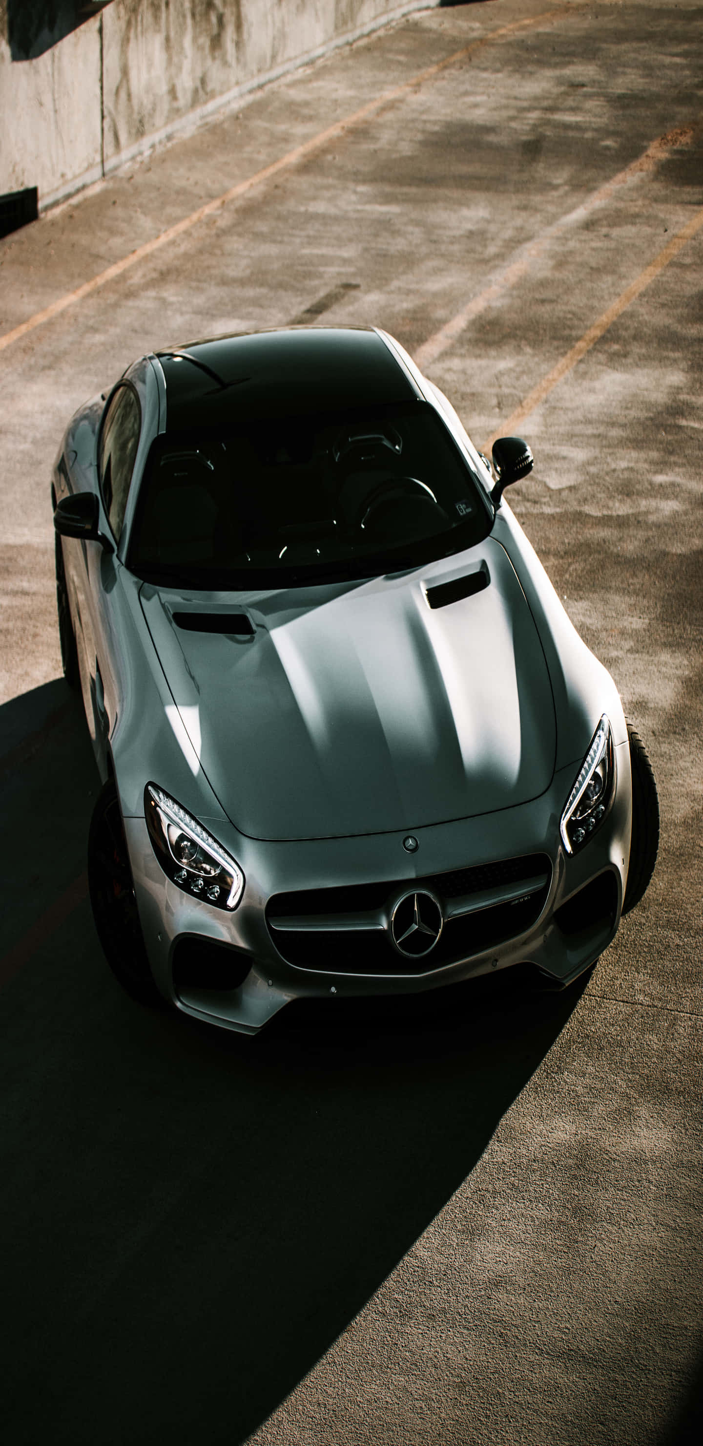 銀色梅賽德斯頂視圖 Pixel 3XL AMG GT-R 背景 壁紙 — 一架時尚的銀色 Mercedes-AMG GT 停泊在陽光普照的混凝土停車場，投下銳利的陰影。