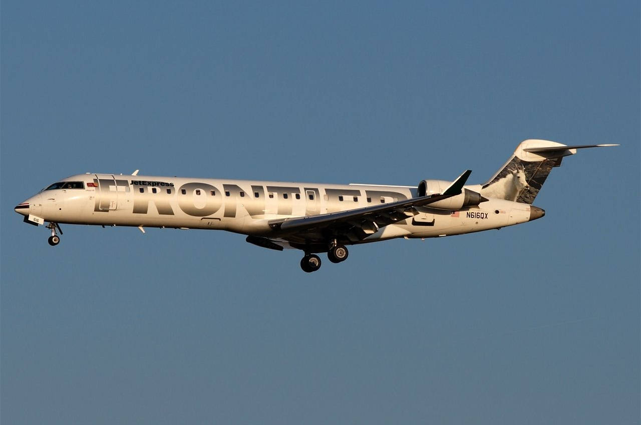 Frontier Airlines 噴射機在晴朗藍天下下降準備著陸