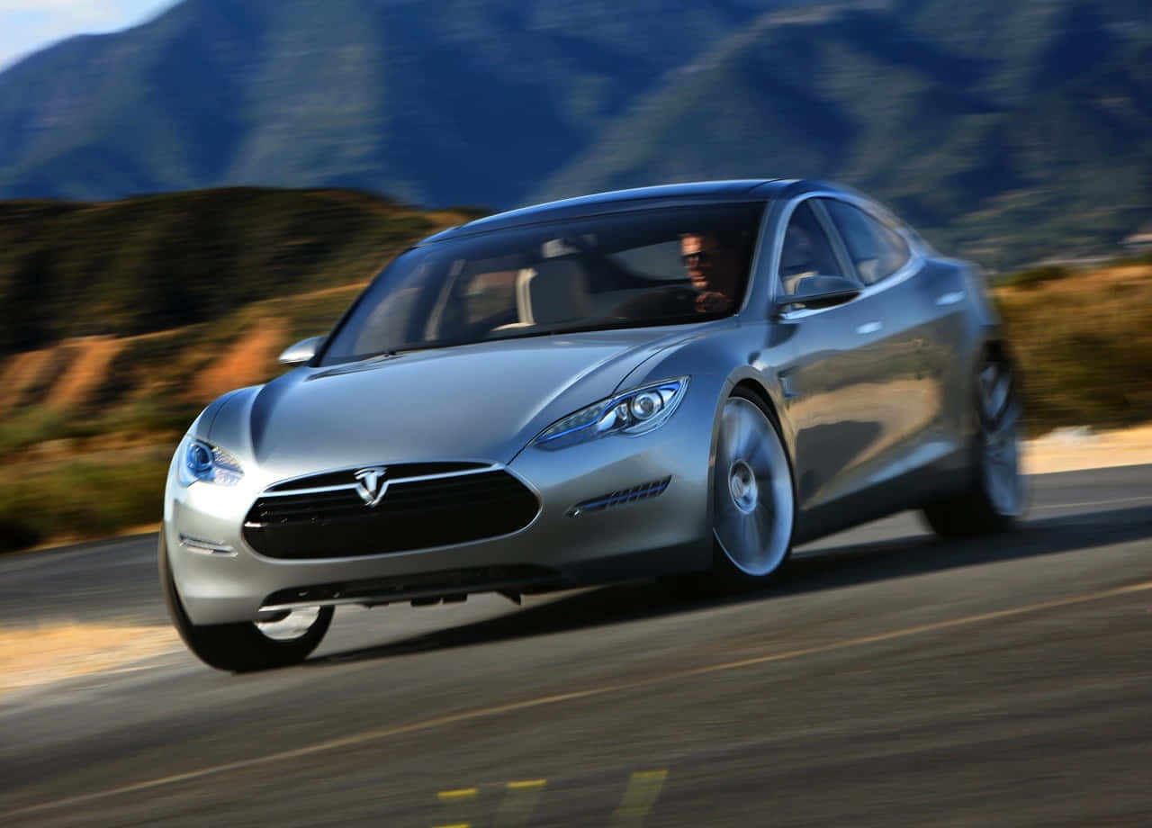 銀色Tesla Model S在日落時分於山路疾馳