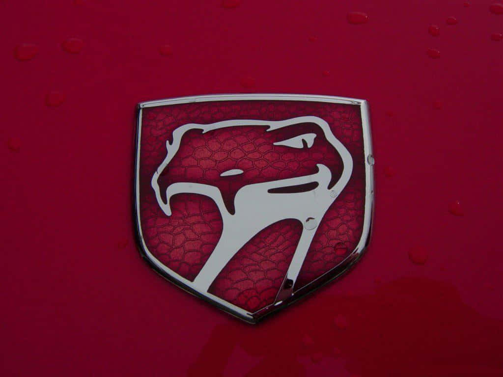 Car Logo 桌布 壁紙 — 銀色蛇標誌特寫，位於光澤紅色汽車引擎蓋上，帶有水珠。
