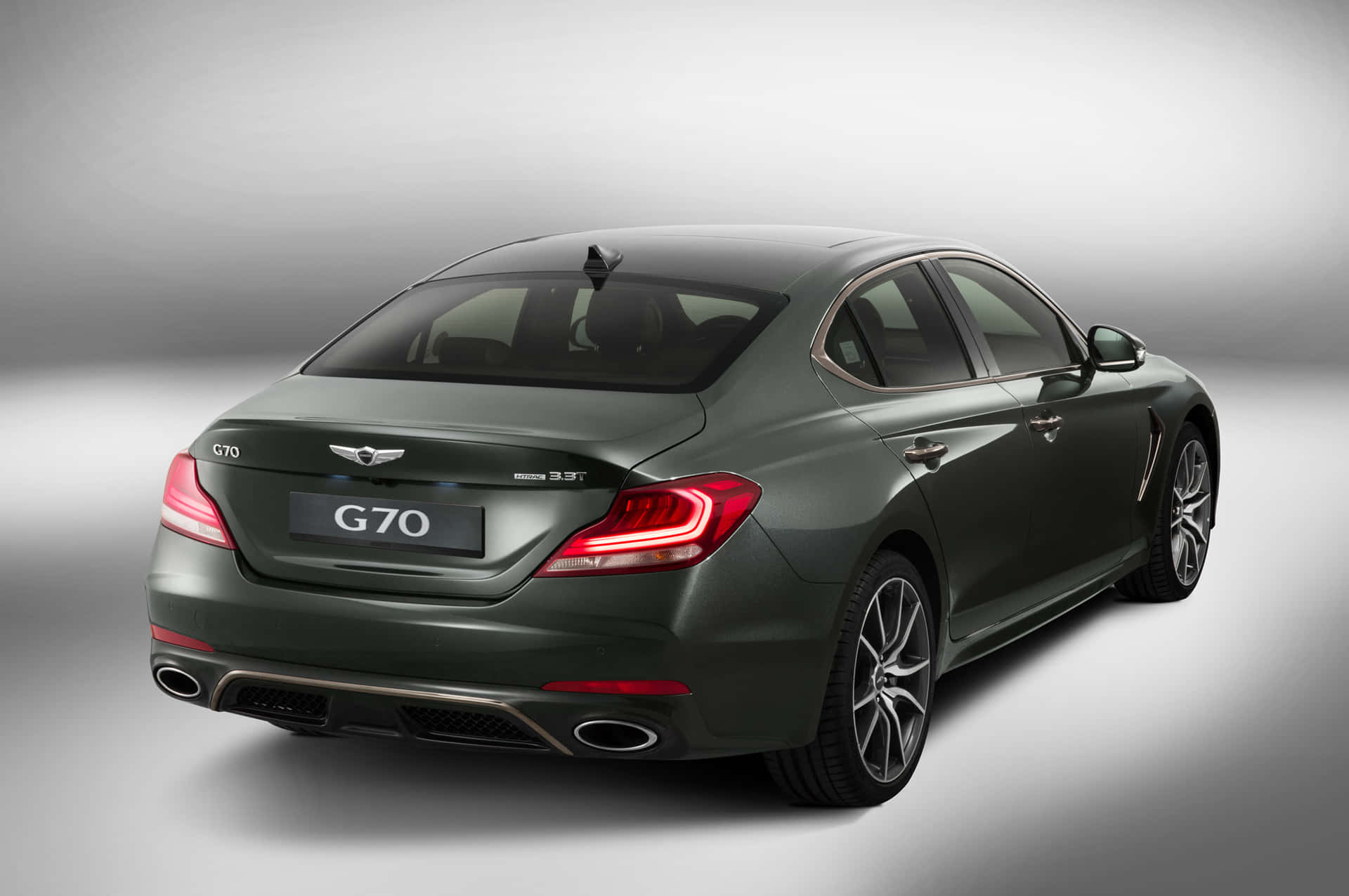 深綠色Genesis G70轎車從後方四分之三角度在工作室環境中觀看。