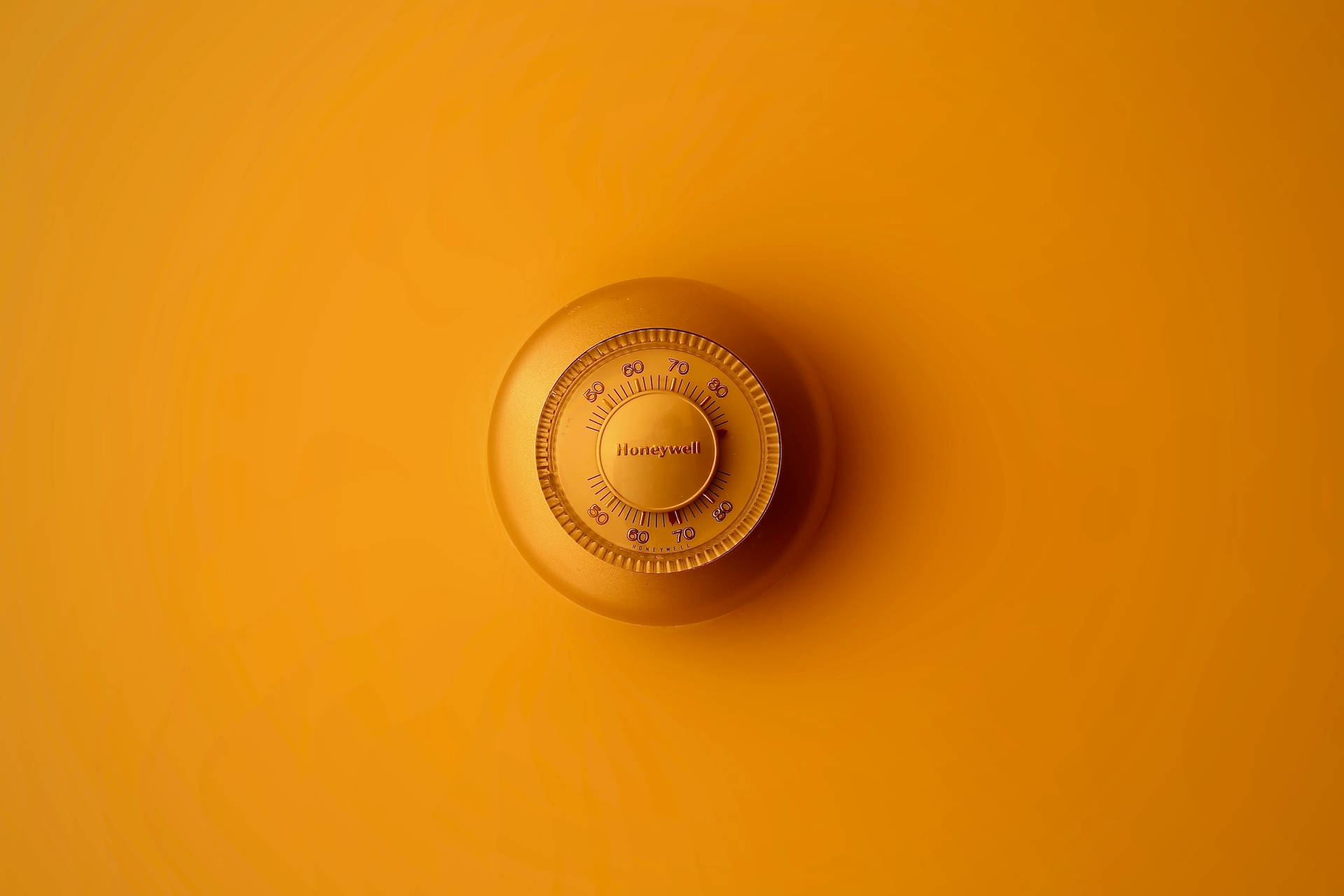 安裝在橙色牆壁上的Honeywell恆溫器。