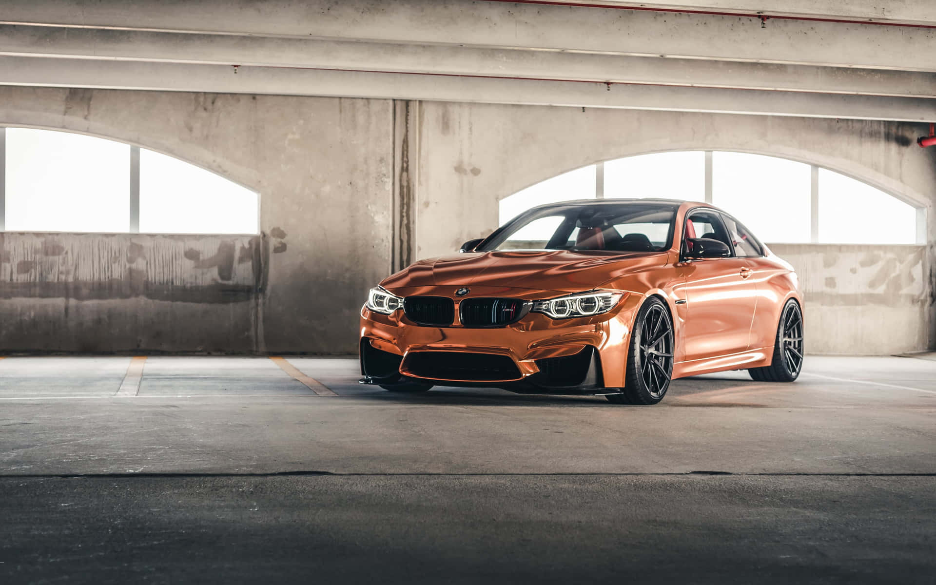 銅色BMW M4雙門跑車停放在混凝土停車場中。