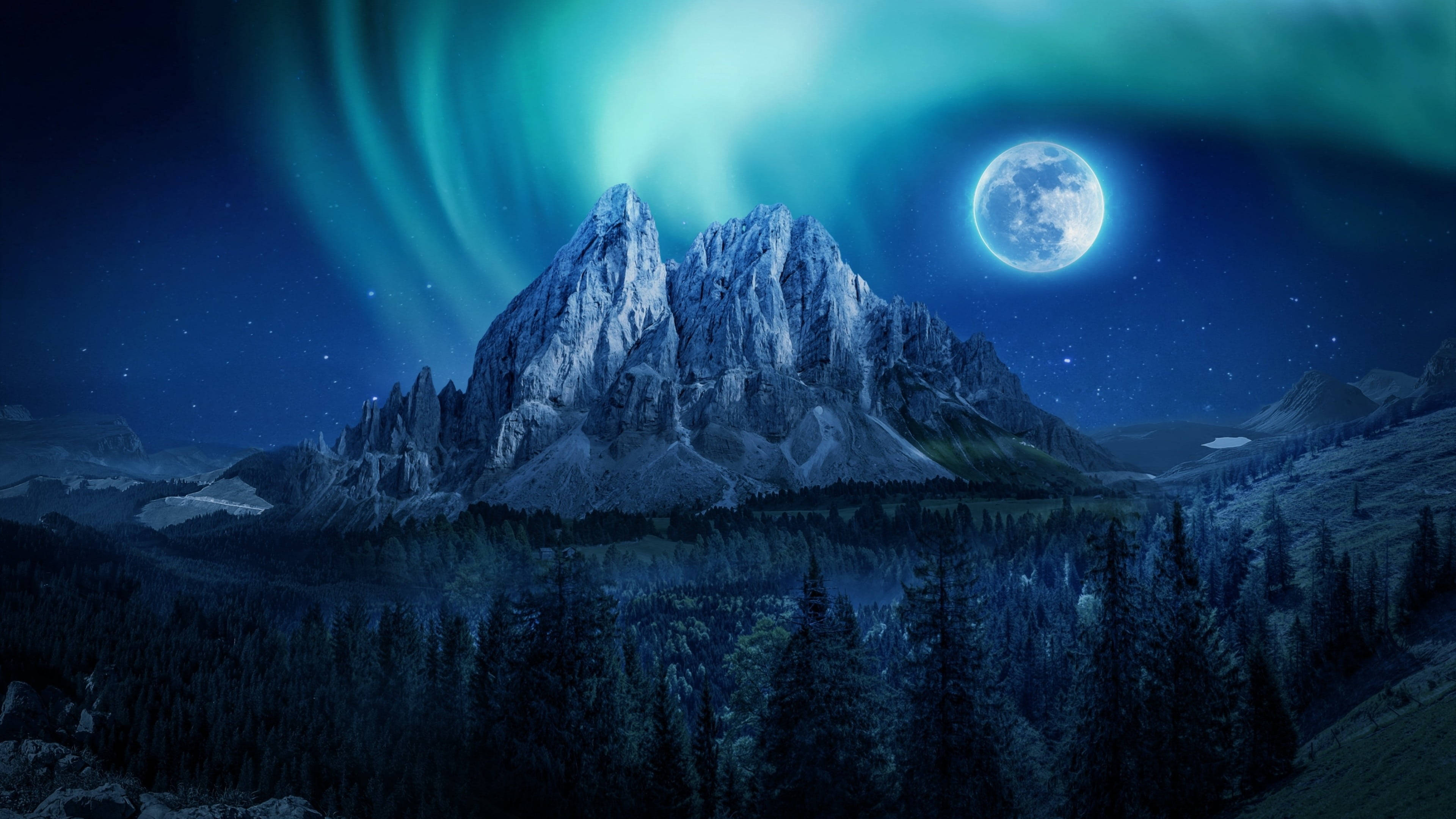 full moon 桌布 壁紙 — 鋸齒狀的山峰在發光的極光和滿月下升起，下方是夜晚的茂密森林。