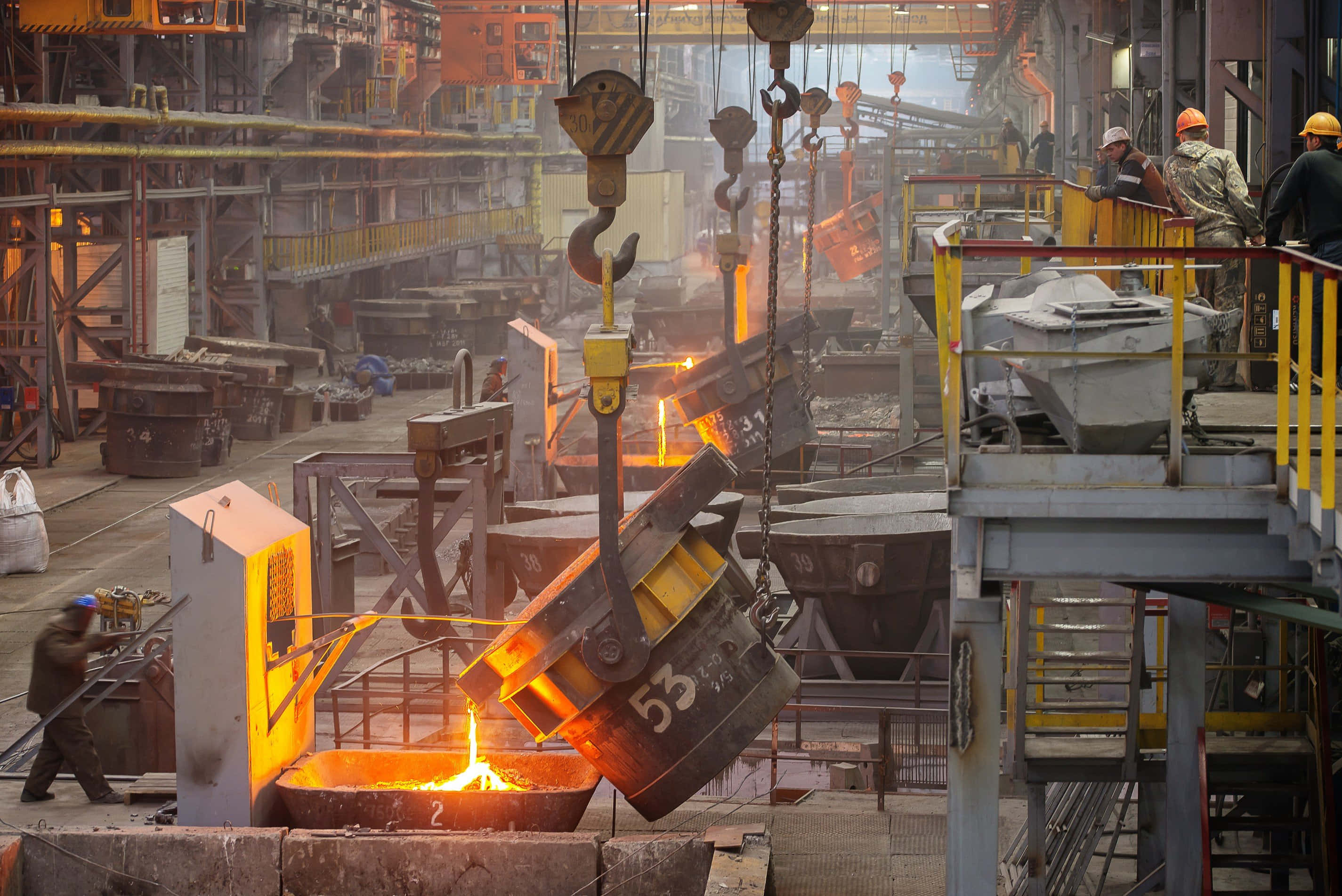 Manufacturing 桌布 壁紙 — 鋼鐵廠工人在工業起重機下，將熾熱的鋼包中的熔融金屬倒入熔爐。