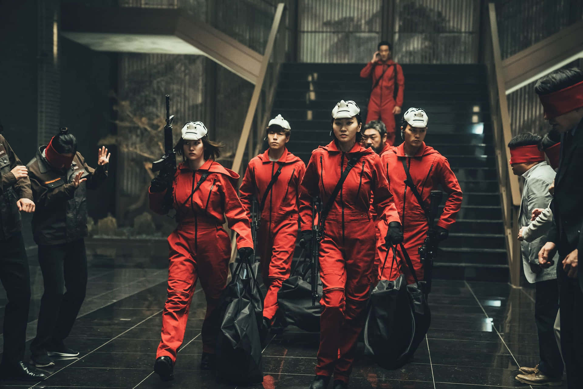 身穿紅色連身衣褲和頭盔的女性手持武器沿樓梯行進。