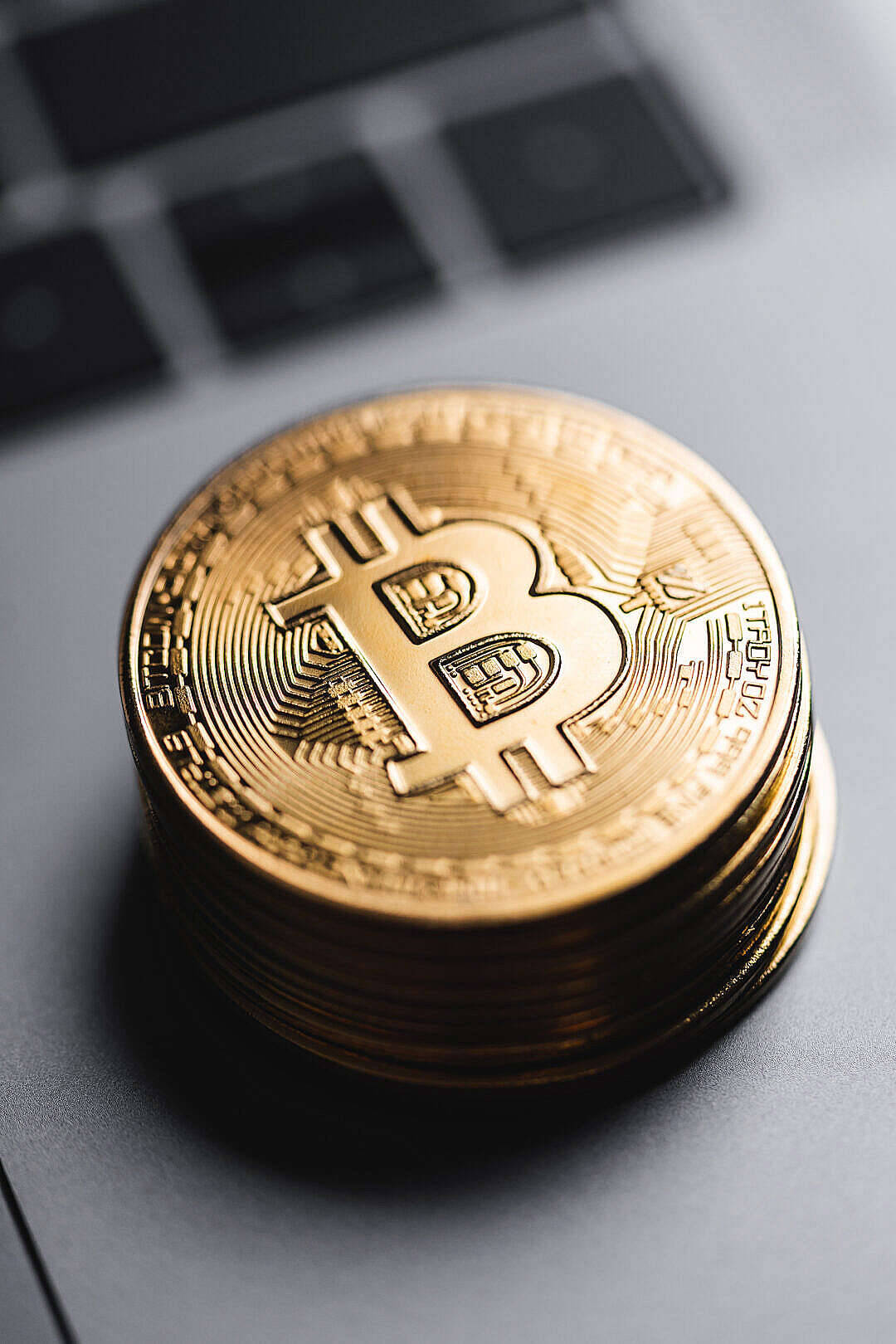 電腦鍵盤上的一堆金色比特幣硬幣。