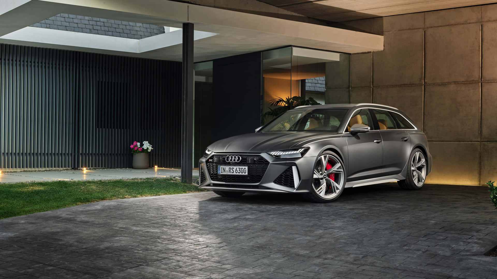 啞光灰色奧迪 RS 6 Avant 夜間停在現代混凝土結構下。